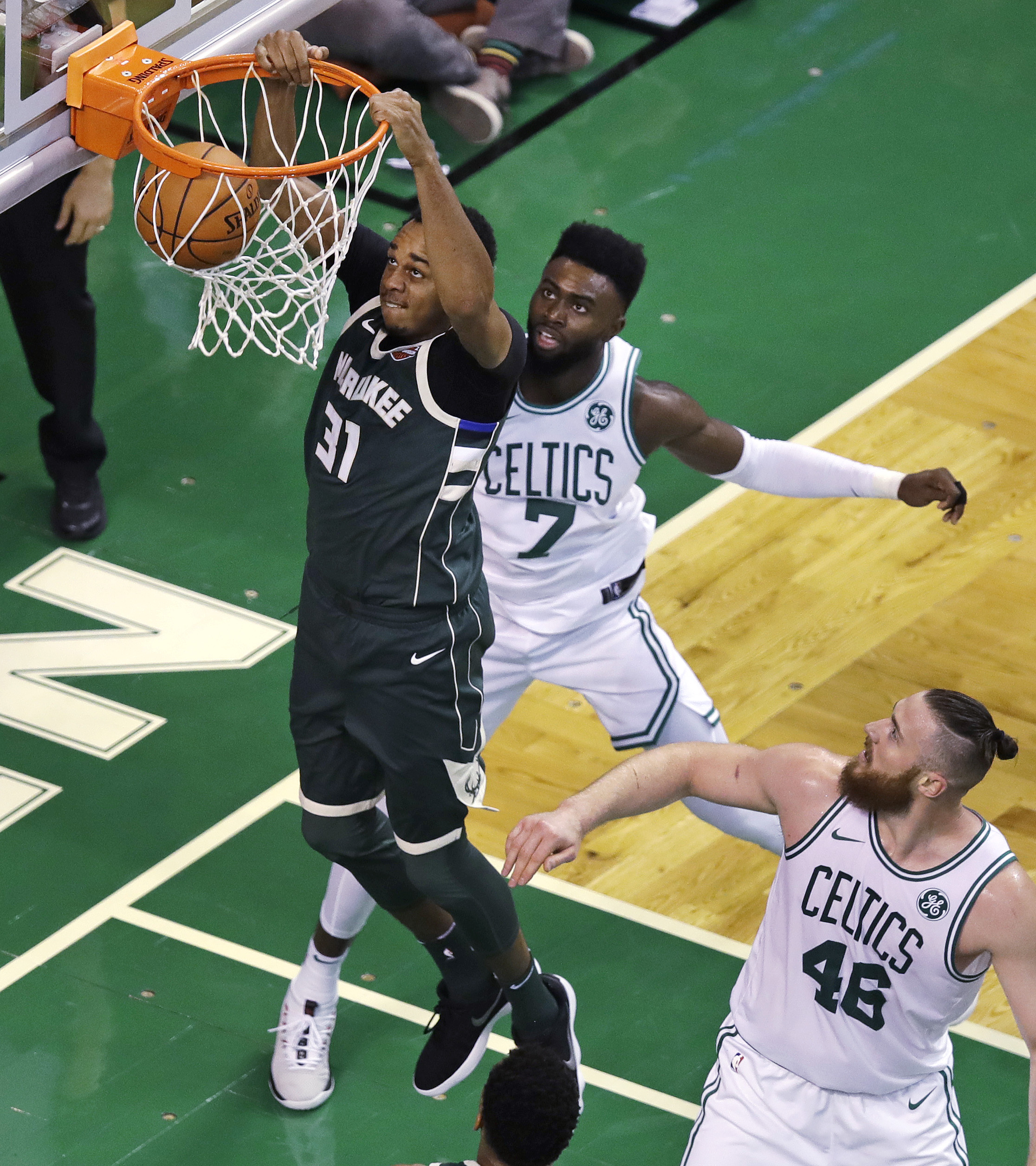 Milwaukee forward John Henson (31) scores a slam dunk against Celtics forward Jaylen Brown (7) and center Aron Baynes (46) during the fourth quarter of Boston’s home-opeing 108-100 loss to the Bucks Wednesday night.