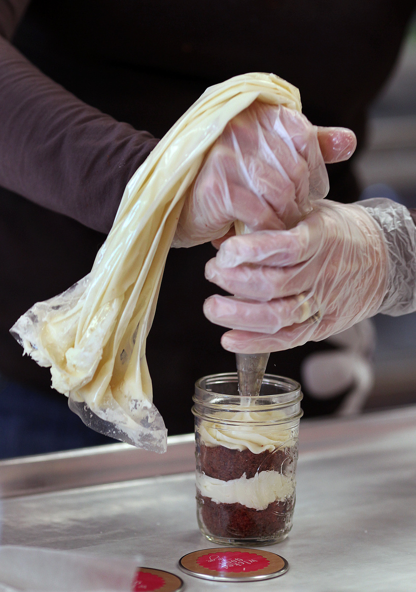 Wicked Good Cupcakes co-owner Tracey Noonan frosts a travel version of “National (Security) Velvet.’’