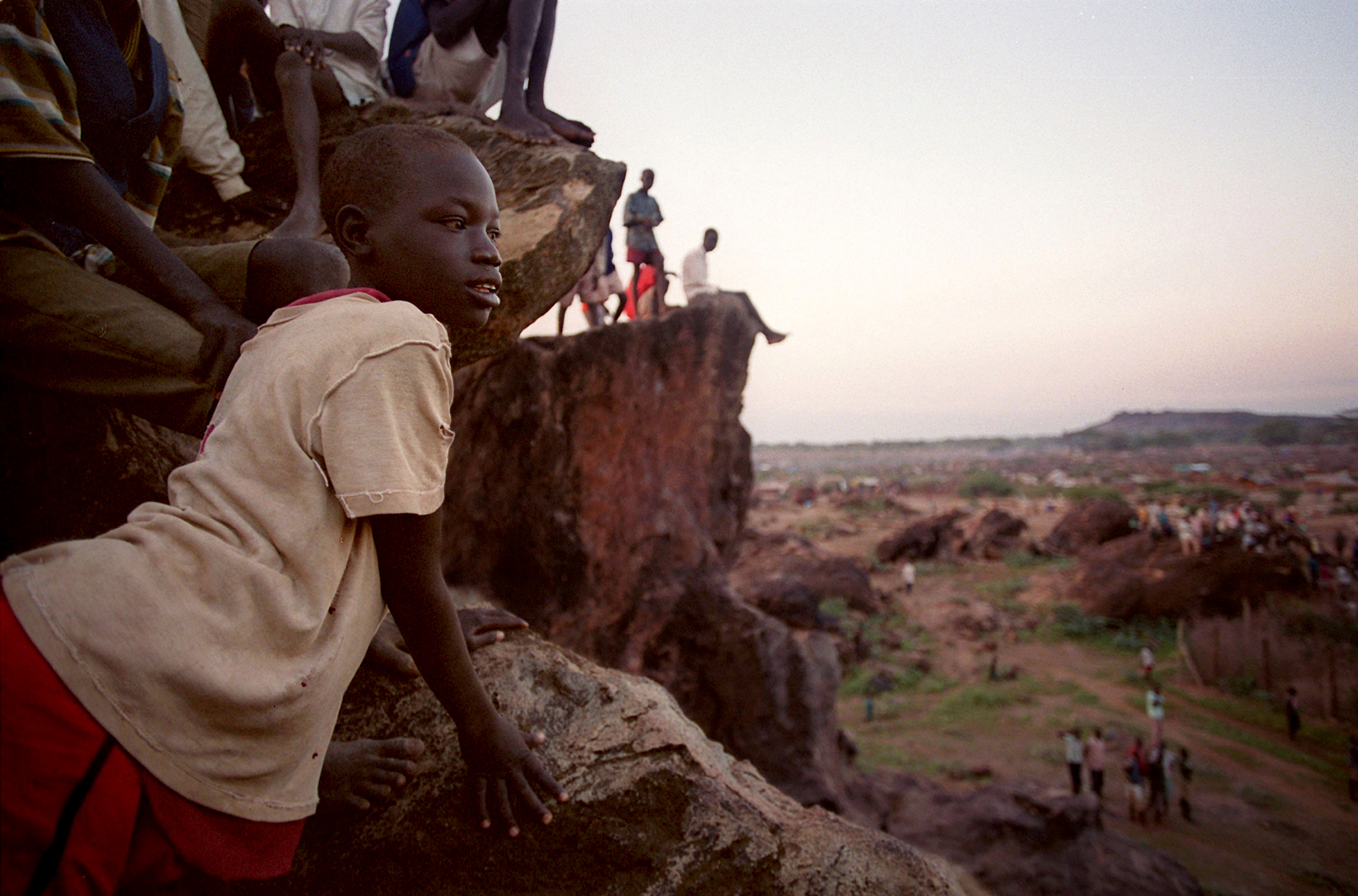 Refugees in the Kakuma camp in Kenya watch distribution of food in 2001, when Sudan also faced drought and starvation.