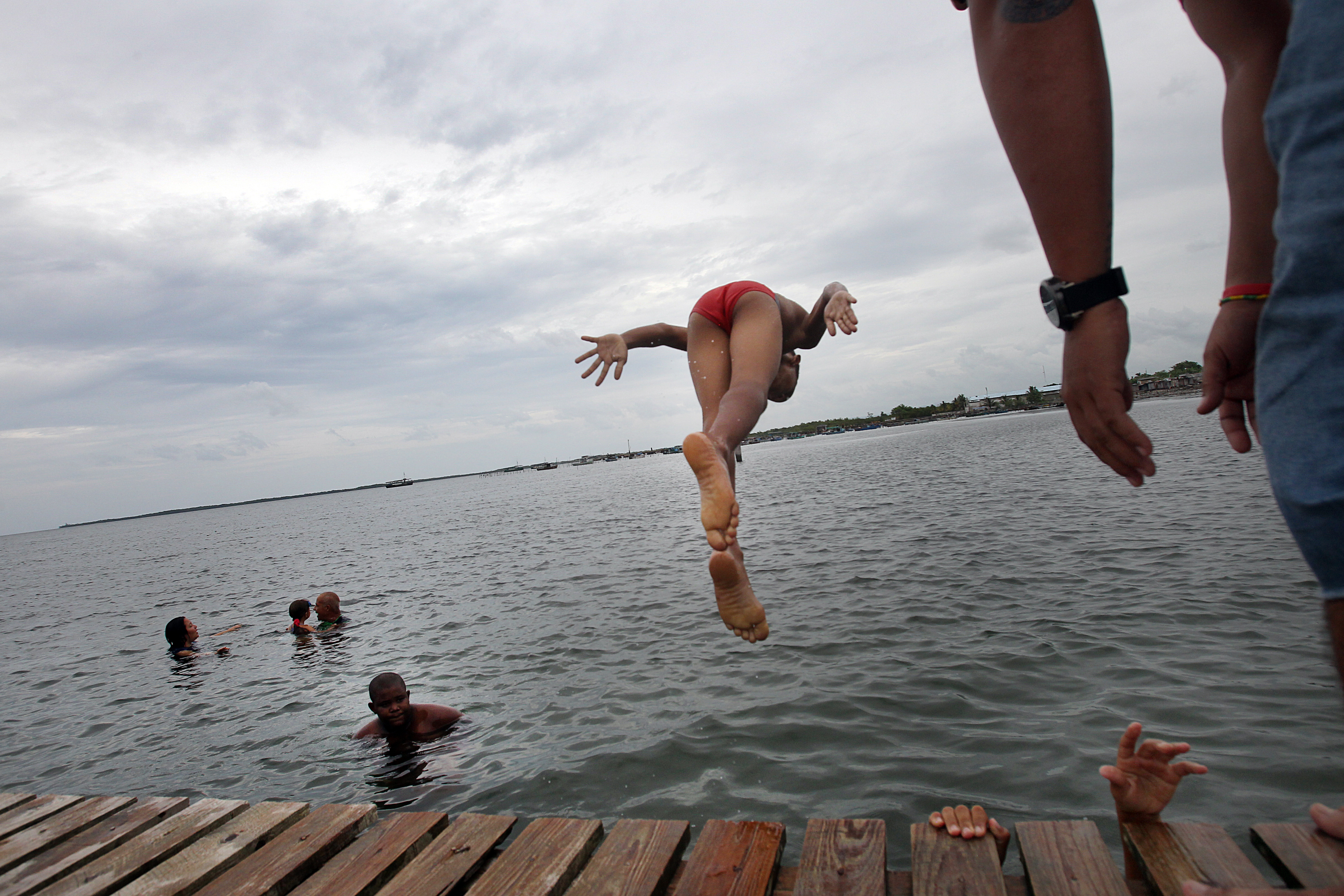 Local villagers jump off the dock in Puerto Esperanza for an afternoon swim.