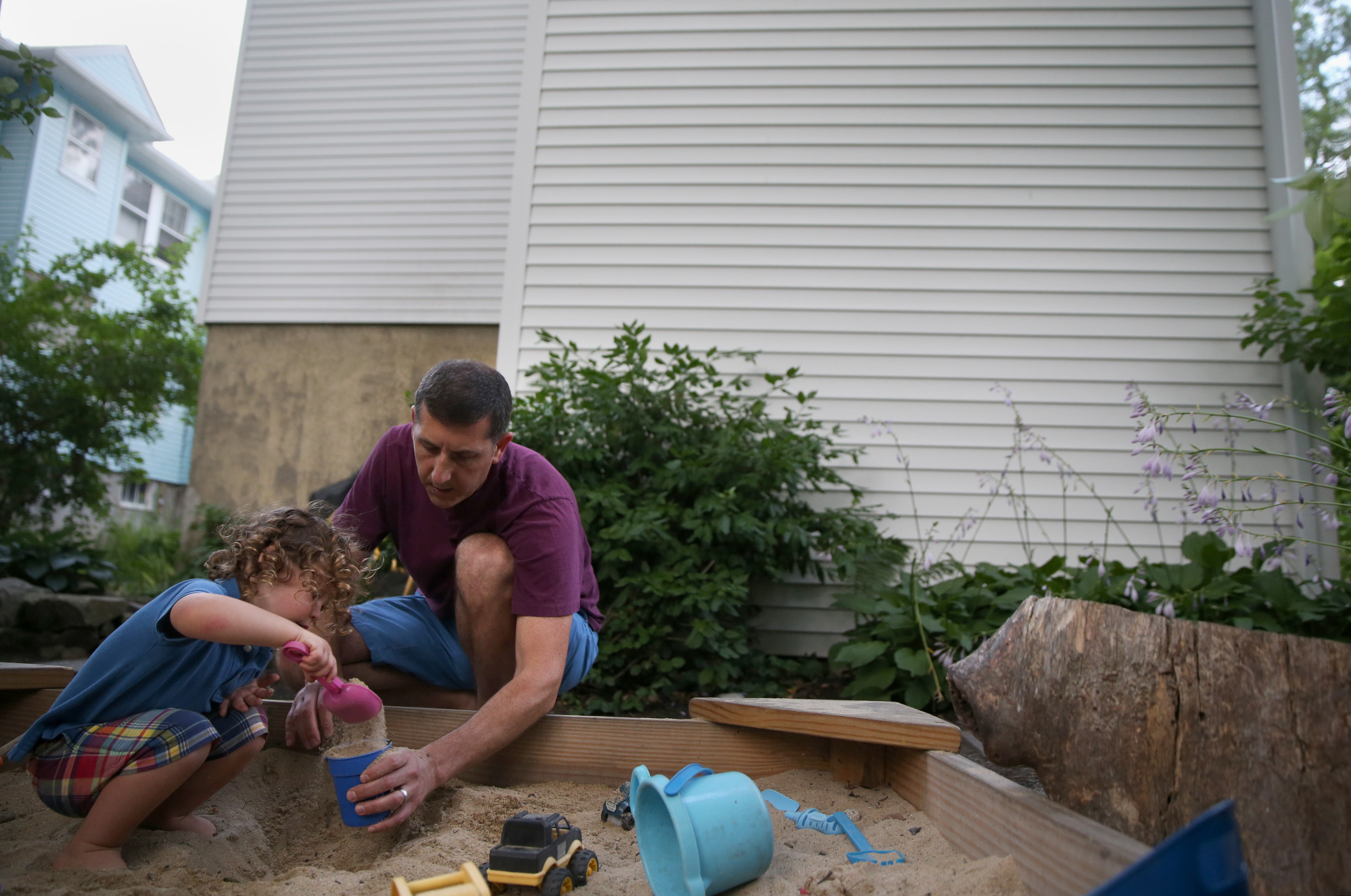 Lennon Faroni, 2, plays with his father, Alex, in the sandbox behind the house they share with cousins.