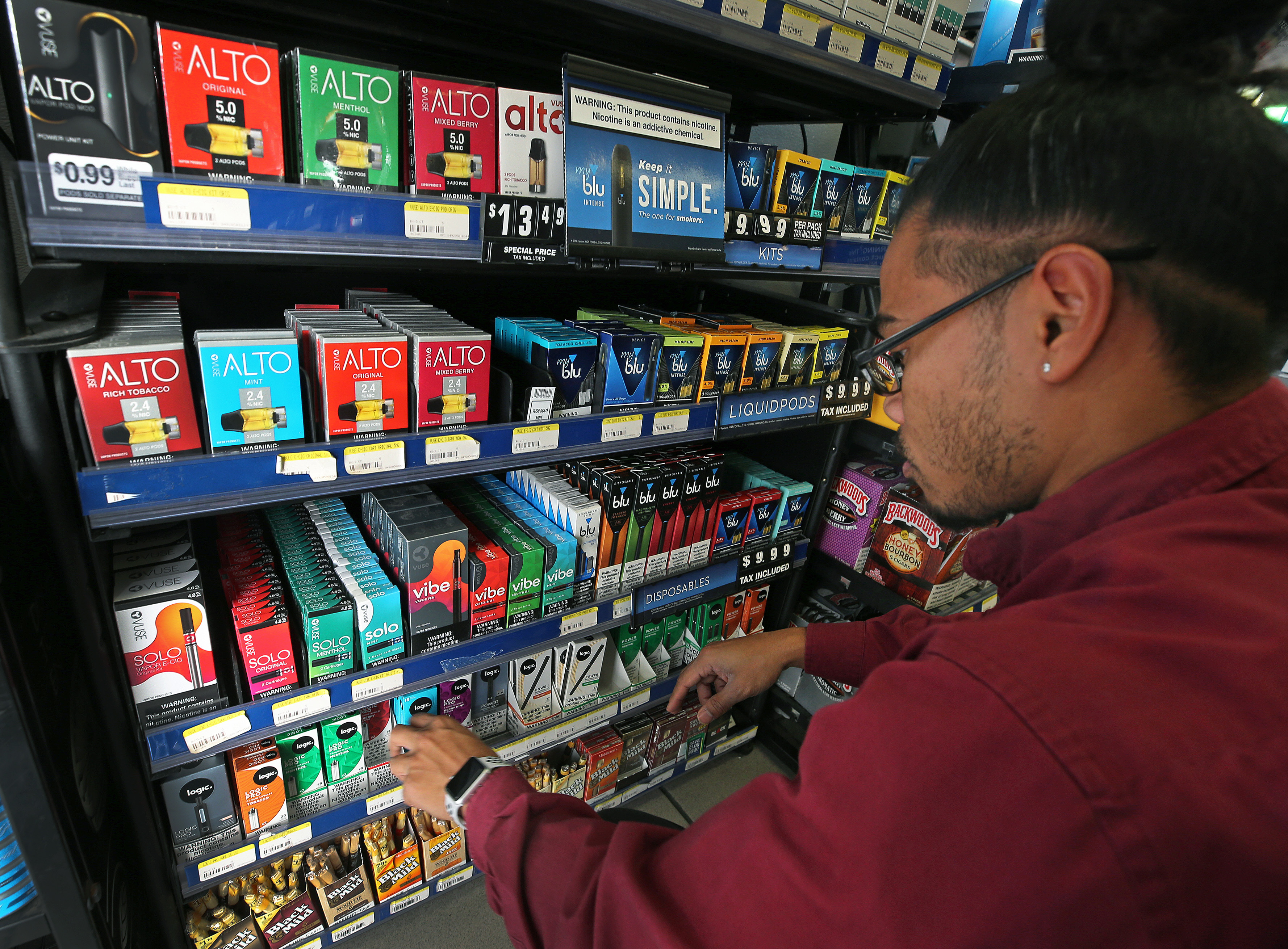 Bona Bunsoeung, an employee at Nashau Gulf on Daniel Webster Highway worked on a display of vaping products behind the counter.