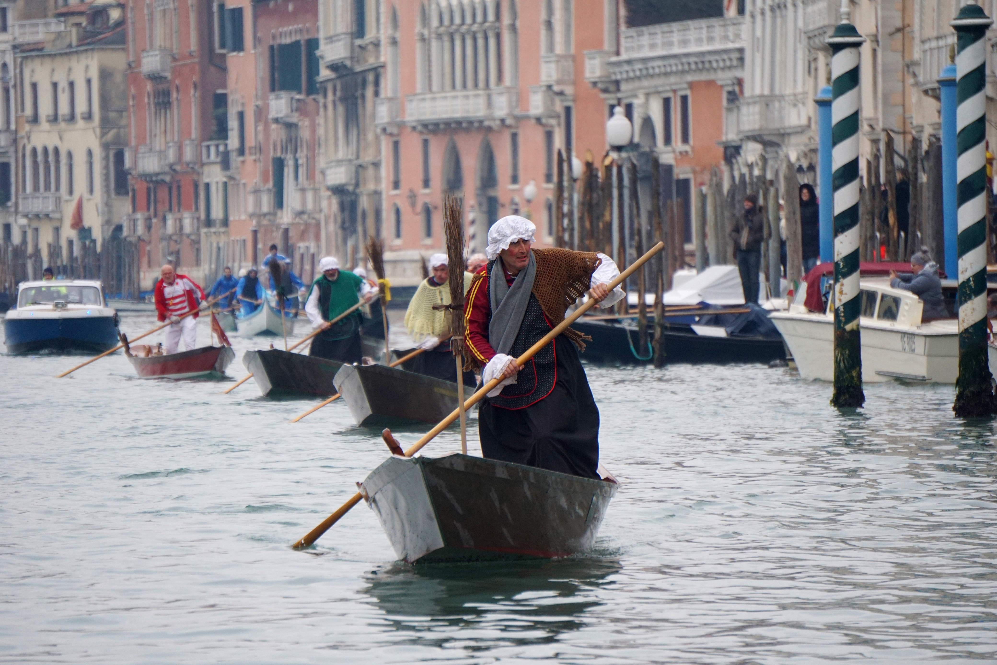 Gondoliers disguised as old women row on the Grand Canal in Venice, Italy, during the regatta.