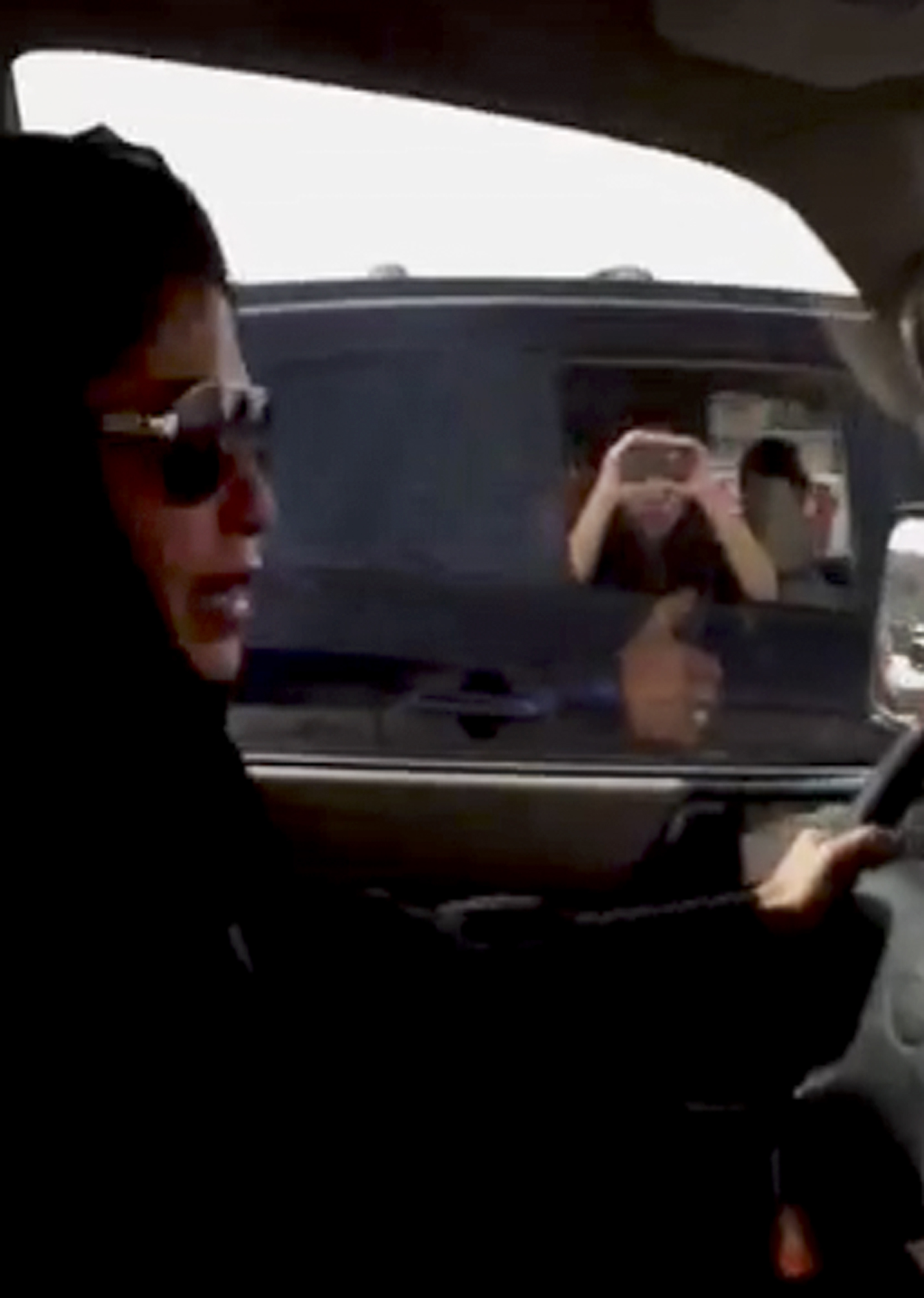 The passenger of a passing vehicle looks across as a woman drives her car in defiance of Saudi Arabia’s ban on women driving, in Riyadh, Saudi Arabia, 2011, in this video frame grab from the Saudi Women for Driving coalition.