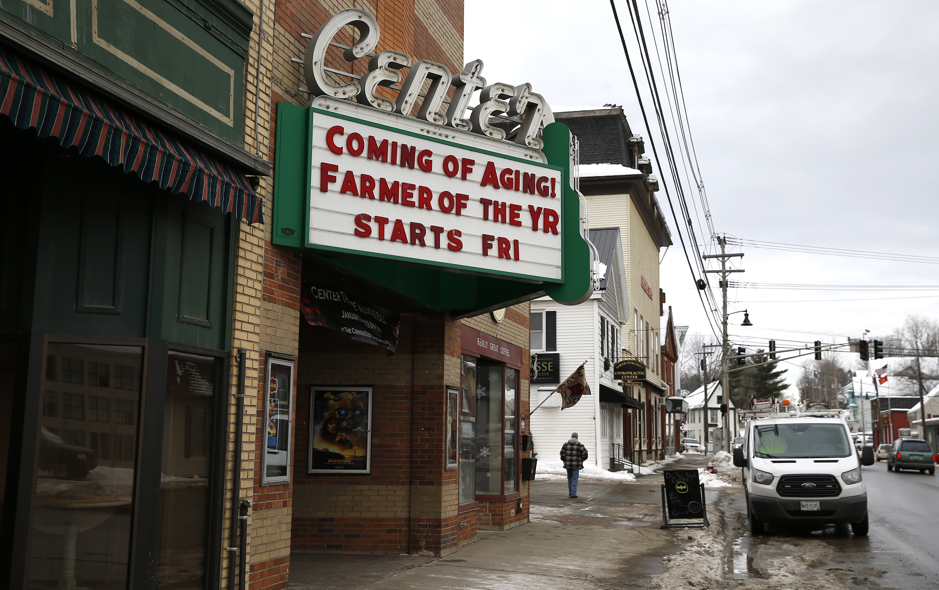 A man walked down East Main Street in Dover-Foxcroft, Maine.