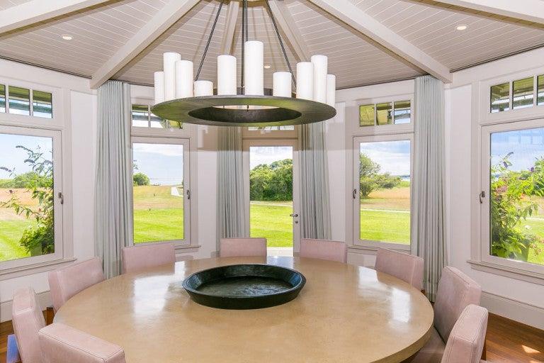 The formal, circular dining room is “surrounded by a wall of windows overlooking the grounds,” according to the listing.