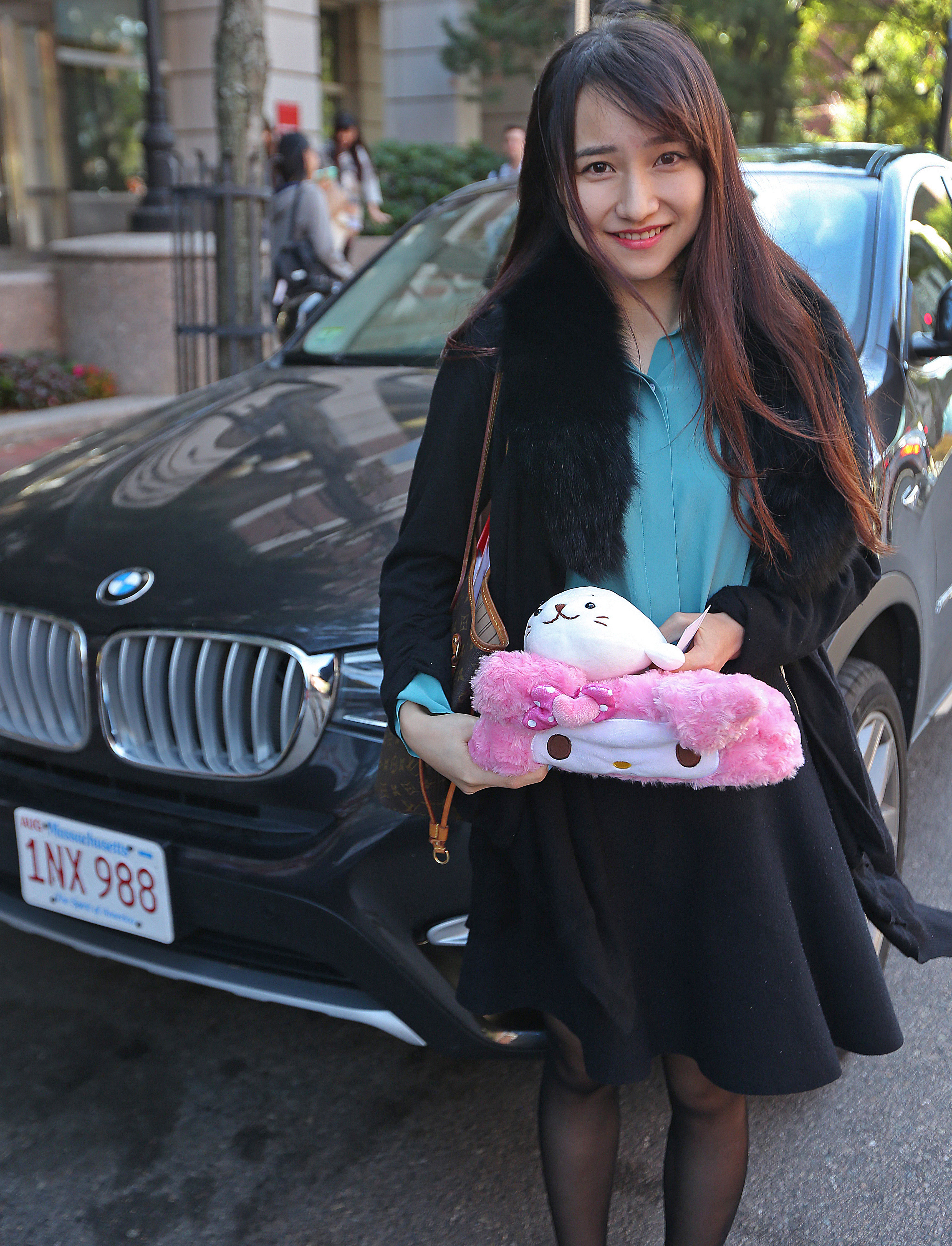 BU student, Tancy Wang from China held her stuffed animal and a tissue box decorated with a little face that she keeps on the dashboard of her BMW parked behind her on Silber Way.