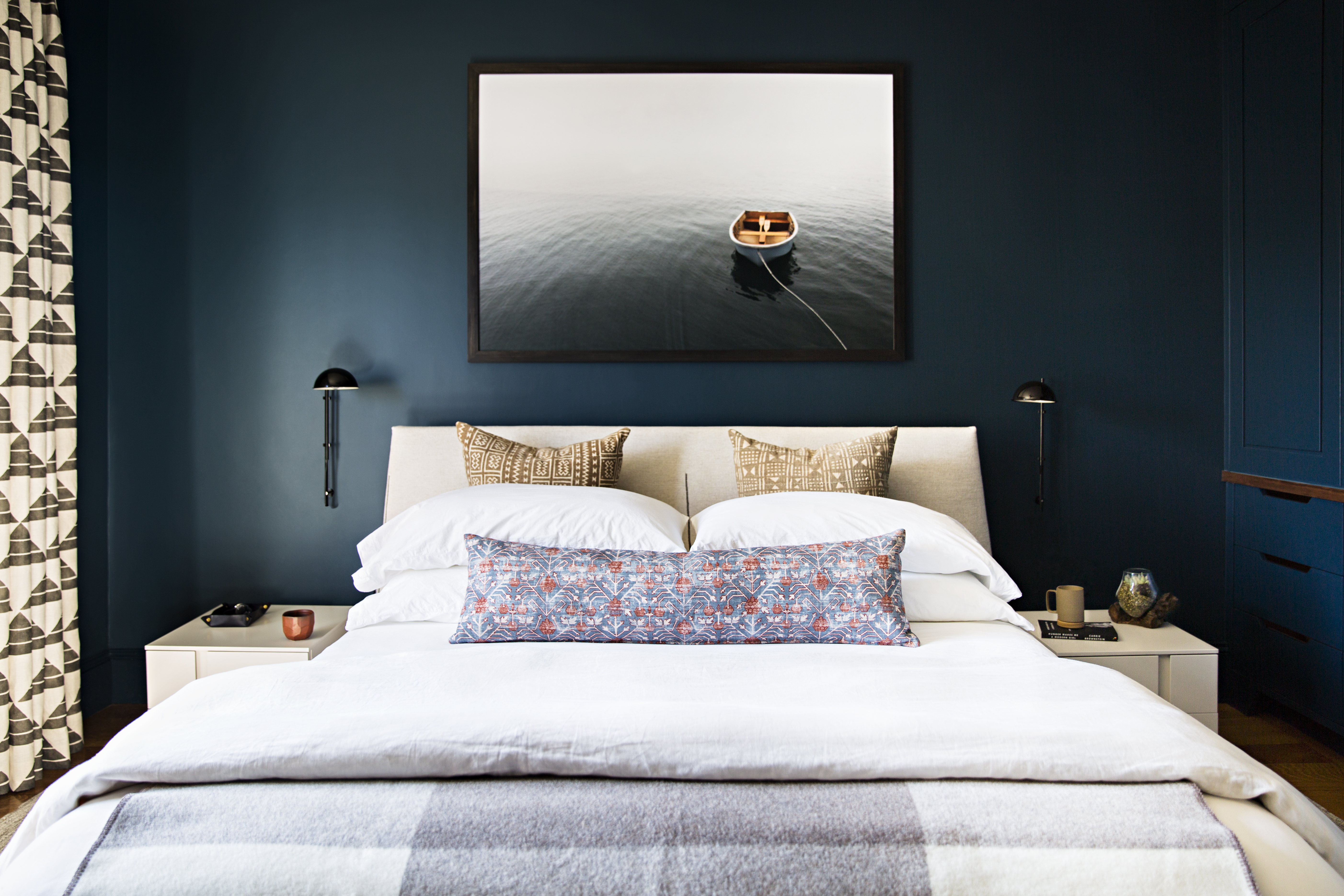 Michael Grimm’s Fog, bought online from Pure Photo, adds to the master bedroom’s moody feel. Khotan fabric from Zak + Fox covers the lumbar pillow. The crisp, Japanese-inspired geometric pattern of the linen drapes is Uroko, also from Zak + Fox. The upholstered bed and matte lacquer night stands are by the Italian furniture line Jesse, from Casa Design Boston.