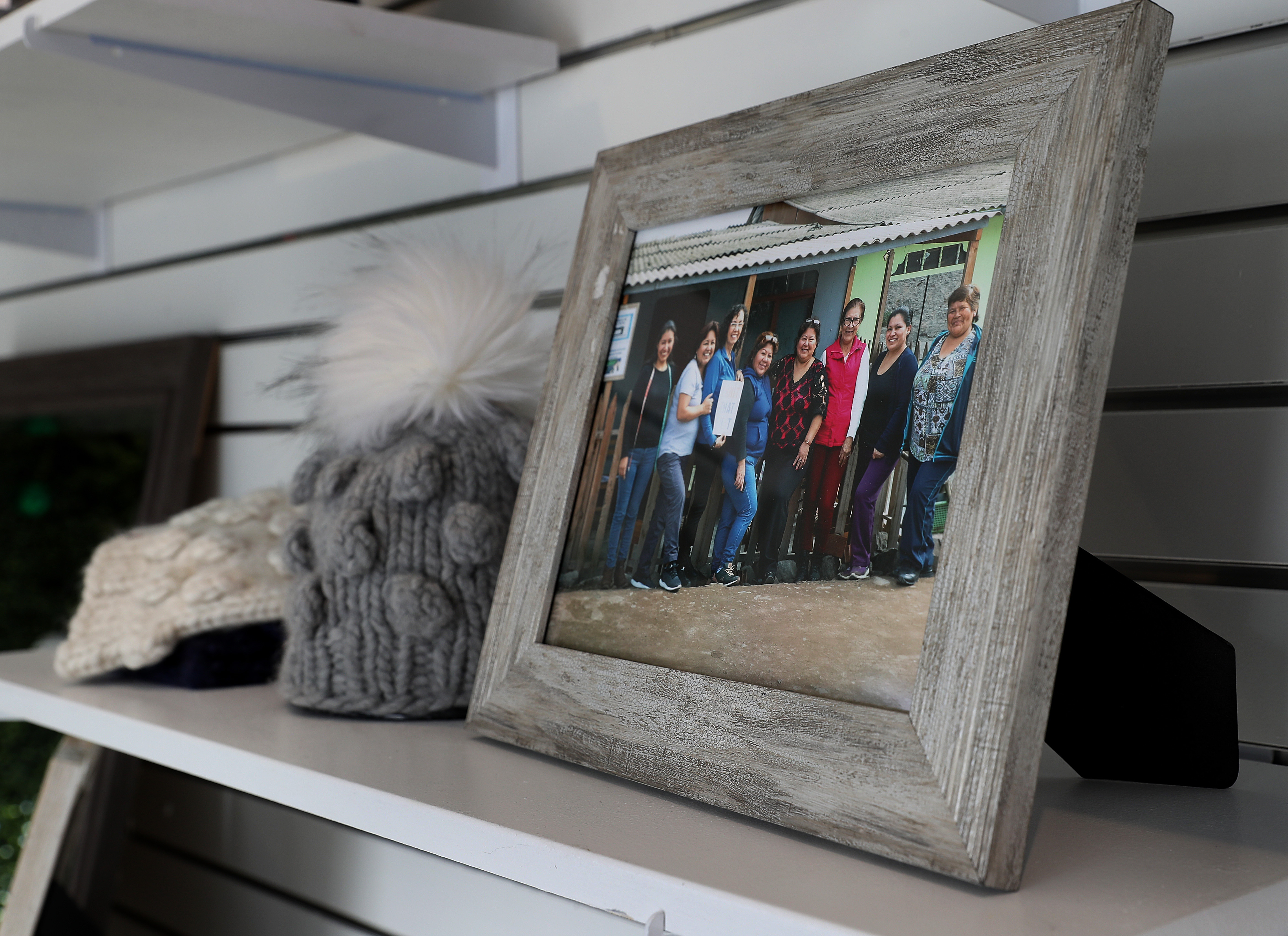 Christina Fagan now has a community of women in Peru who work with her to knit hats and wraps. A photograph showing some of the woman can be seen on the store’s shelf.