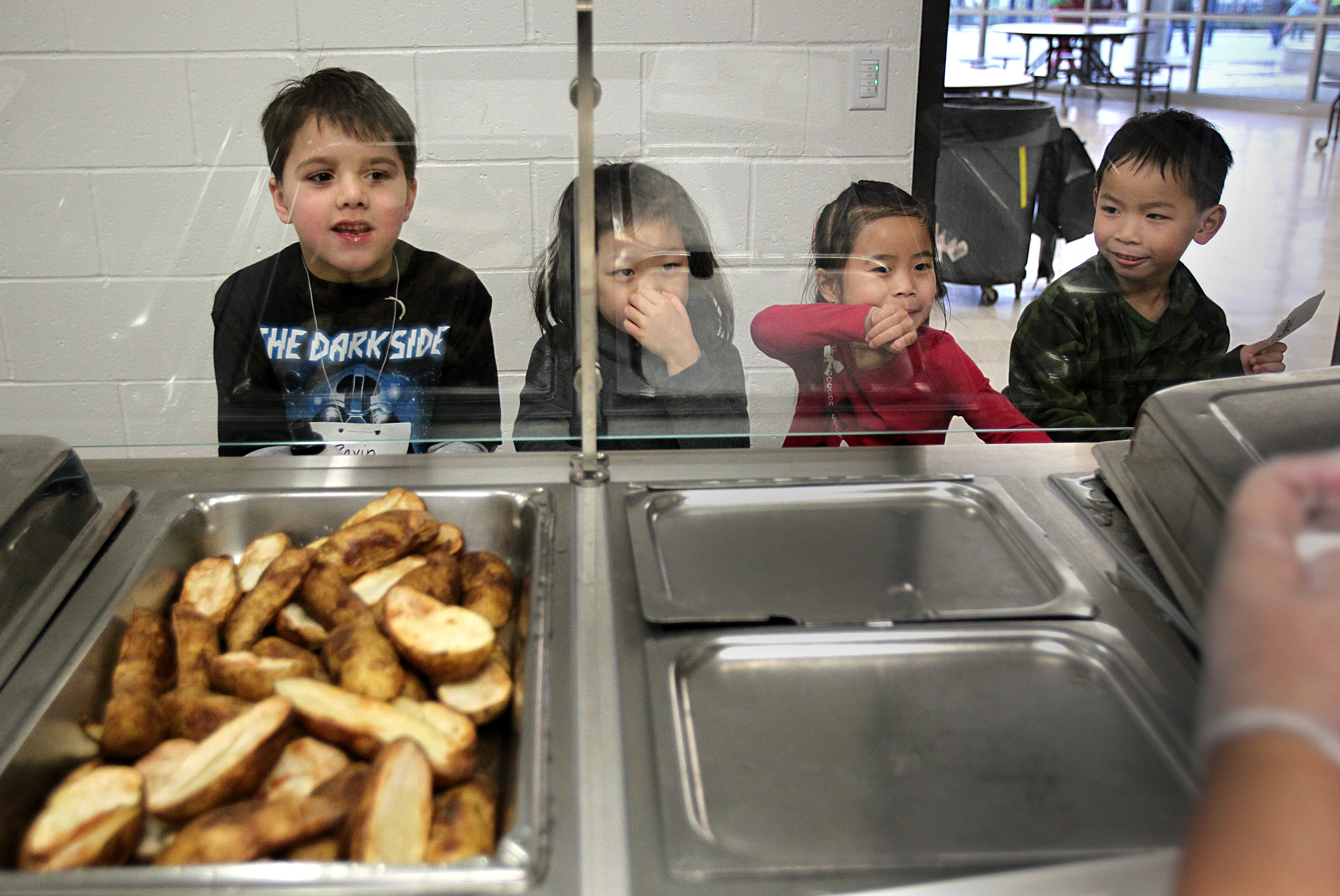 Students (from left) Ravin Bhatia, Jolie Yu, Stephanie Sun, and Grant Keo await lunch at Brookline’s Runkle School.