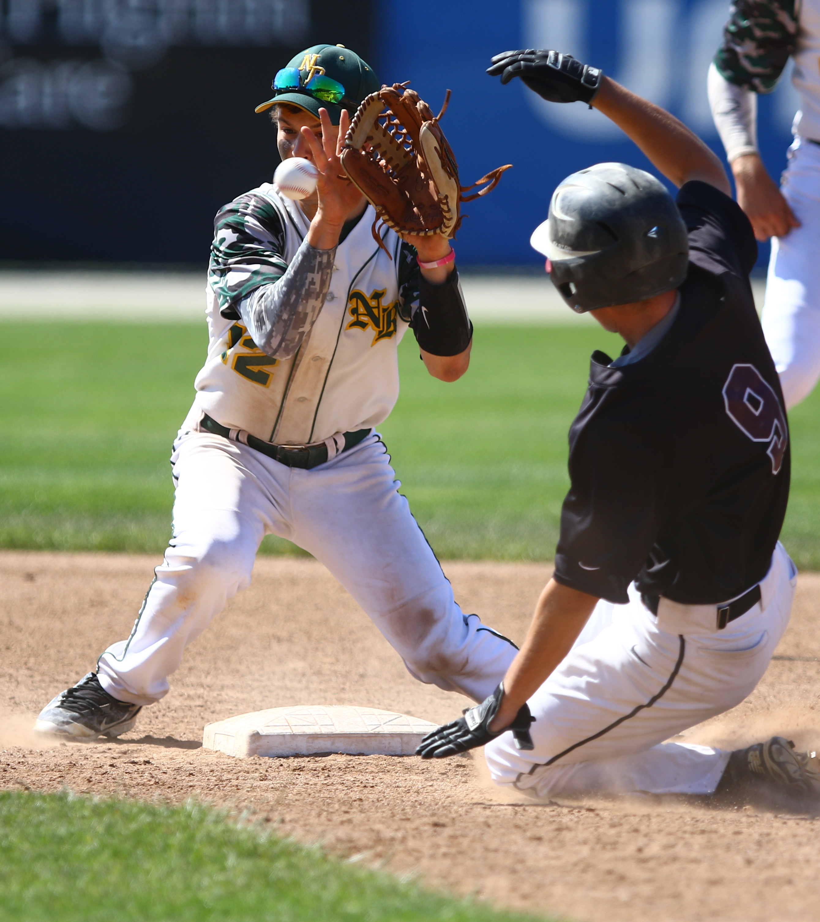 North Reading’s Shawn DiVecchia awaits the throw while Christopher Werner slides into second.