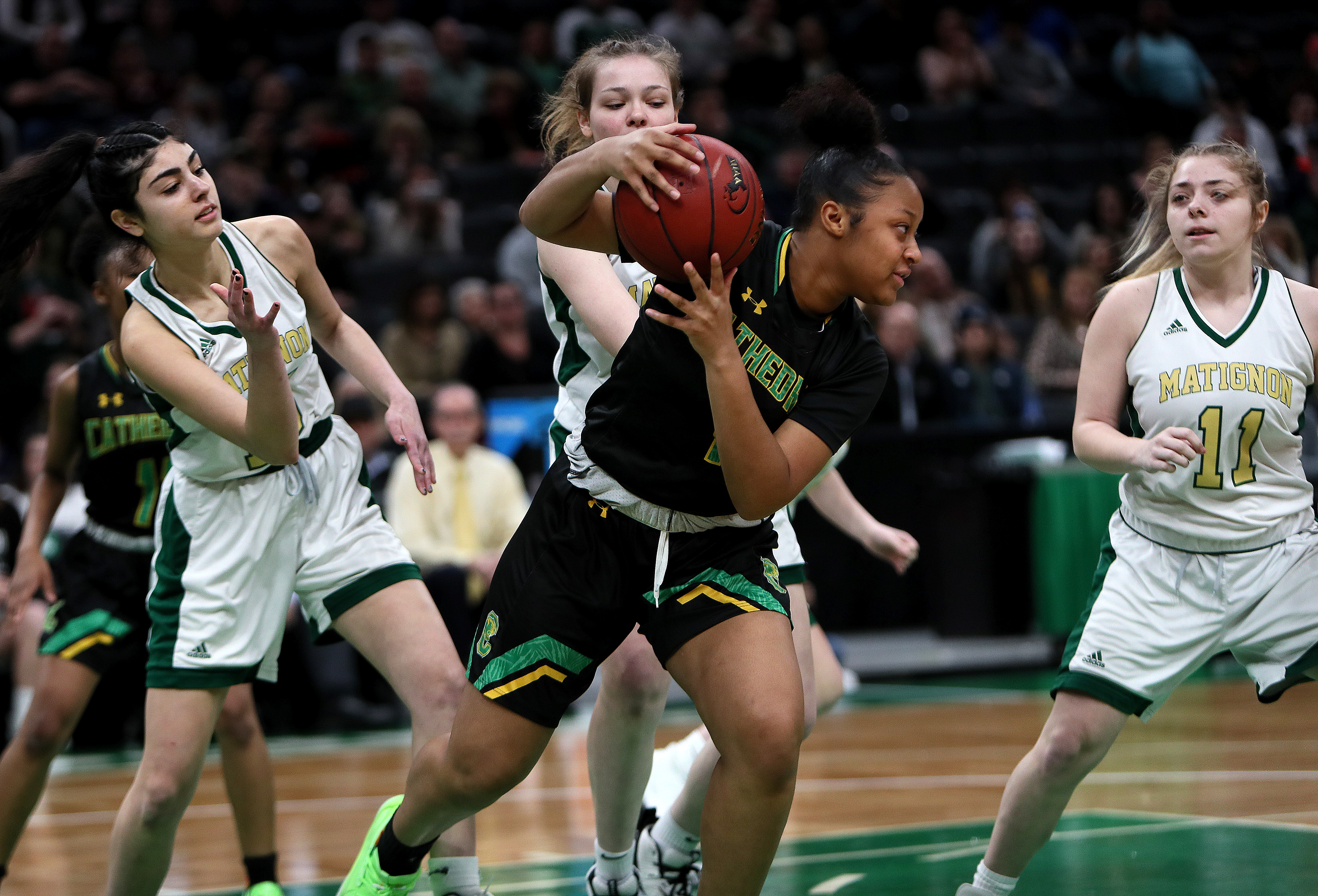 Cathedral's Jordan Fergus grabs a rebound away from a trio of Matignon players during Tuesday's MIAA Division 4 girls' basketball state semifinal at TD Garden.