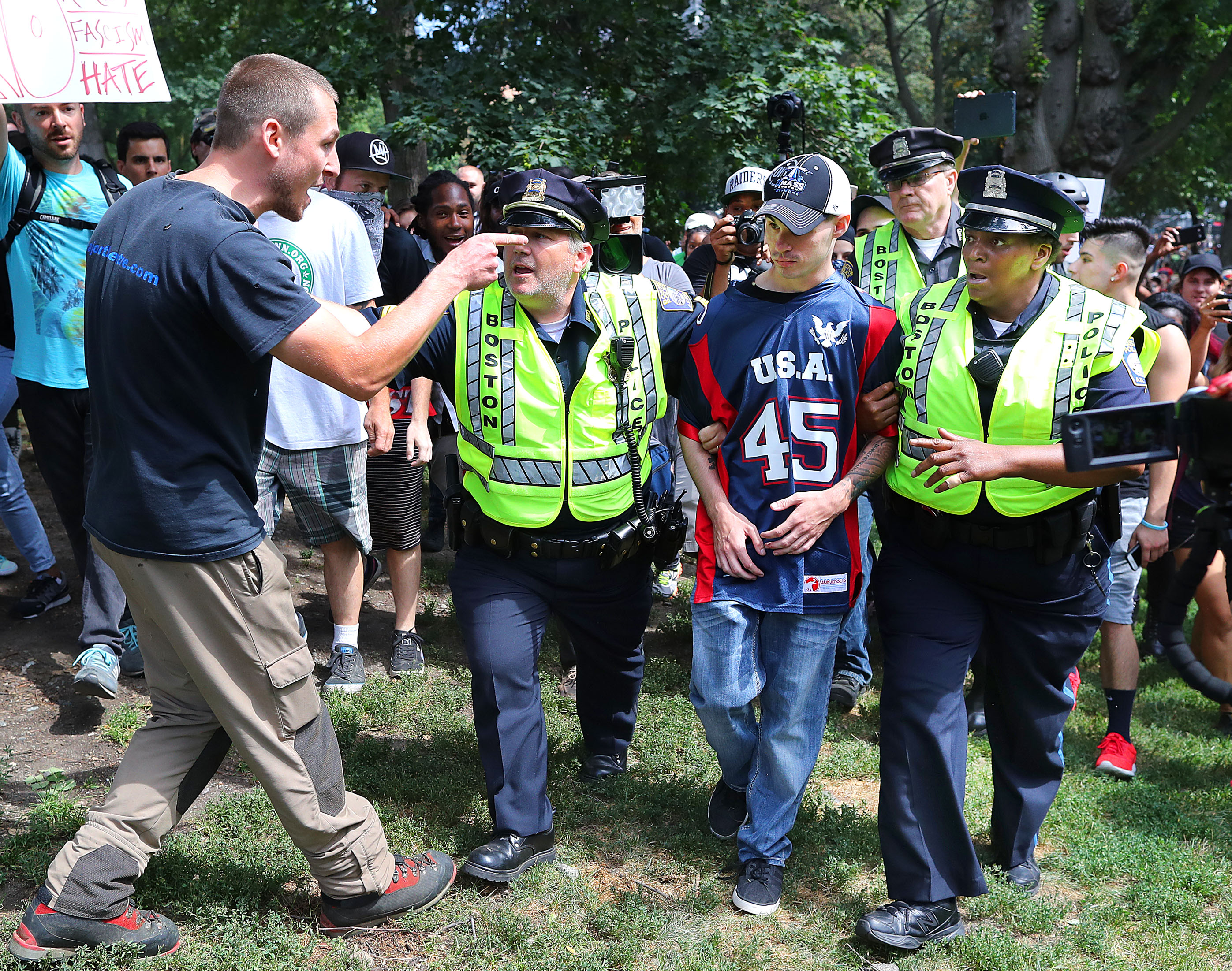 A protester screamed at a “free speech” rally attendee who was escorted away by police.