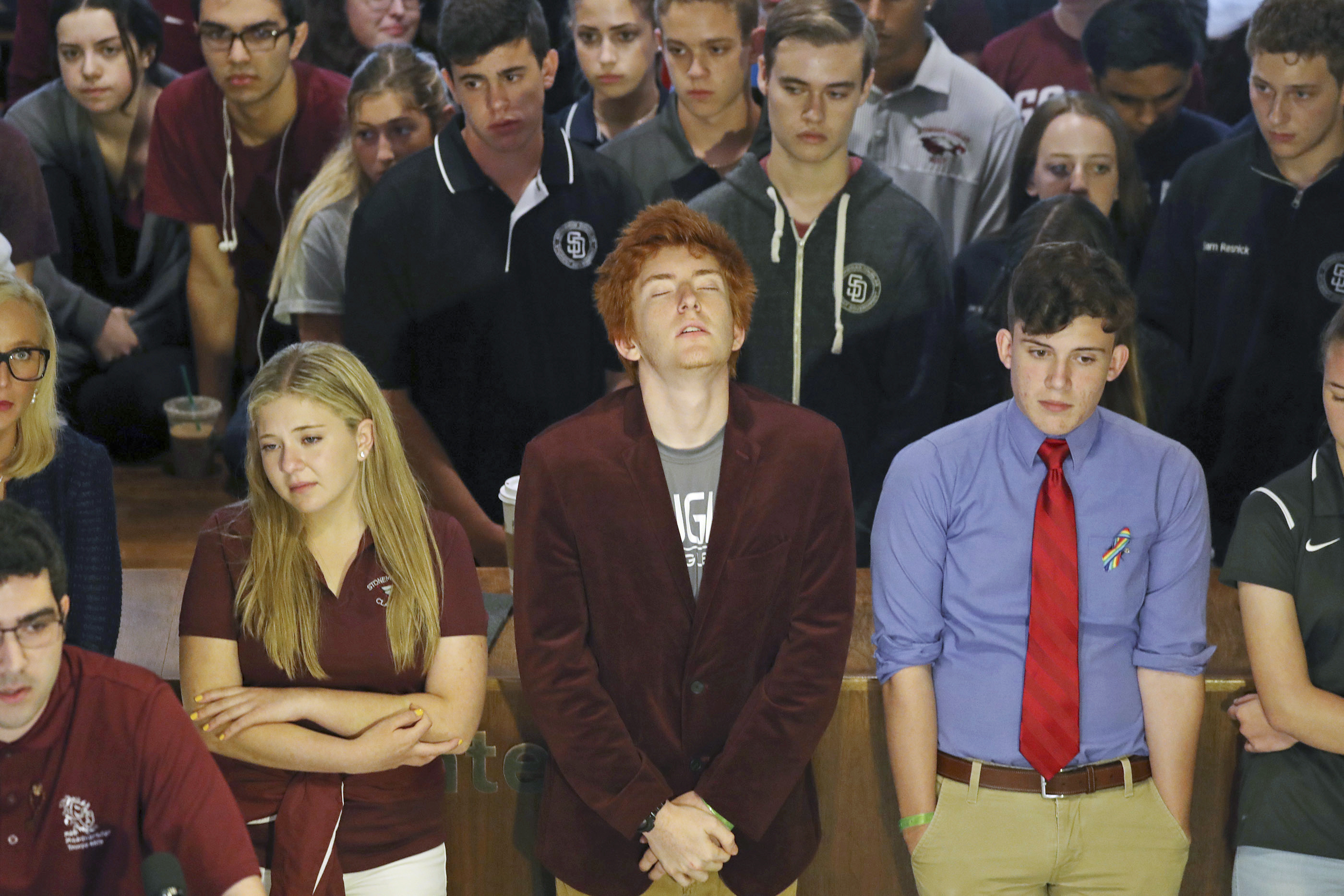 Jaclyn Corin, Ryan Deitsch and Alfonso Calderon along with their classmates from Marjory Stoneman Douglas High School listen as fellow student Lorenzo Prado speaks at a news conference recalling the day of the shooting.