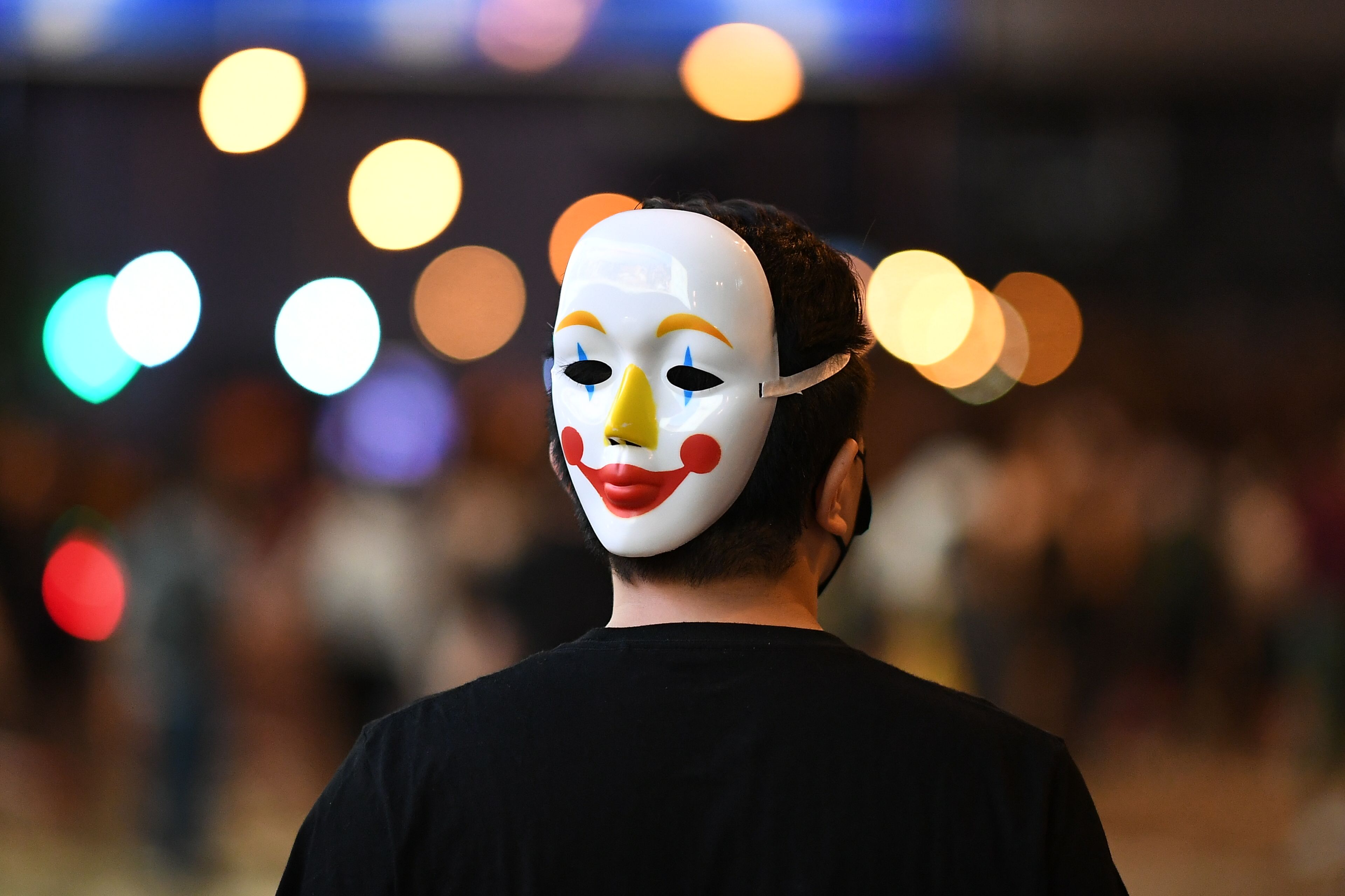 A man wore a mask on the back of his head.