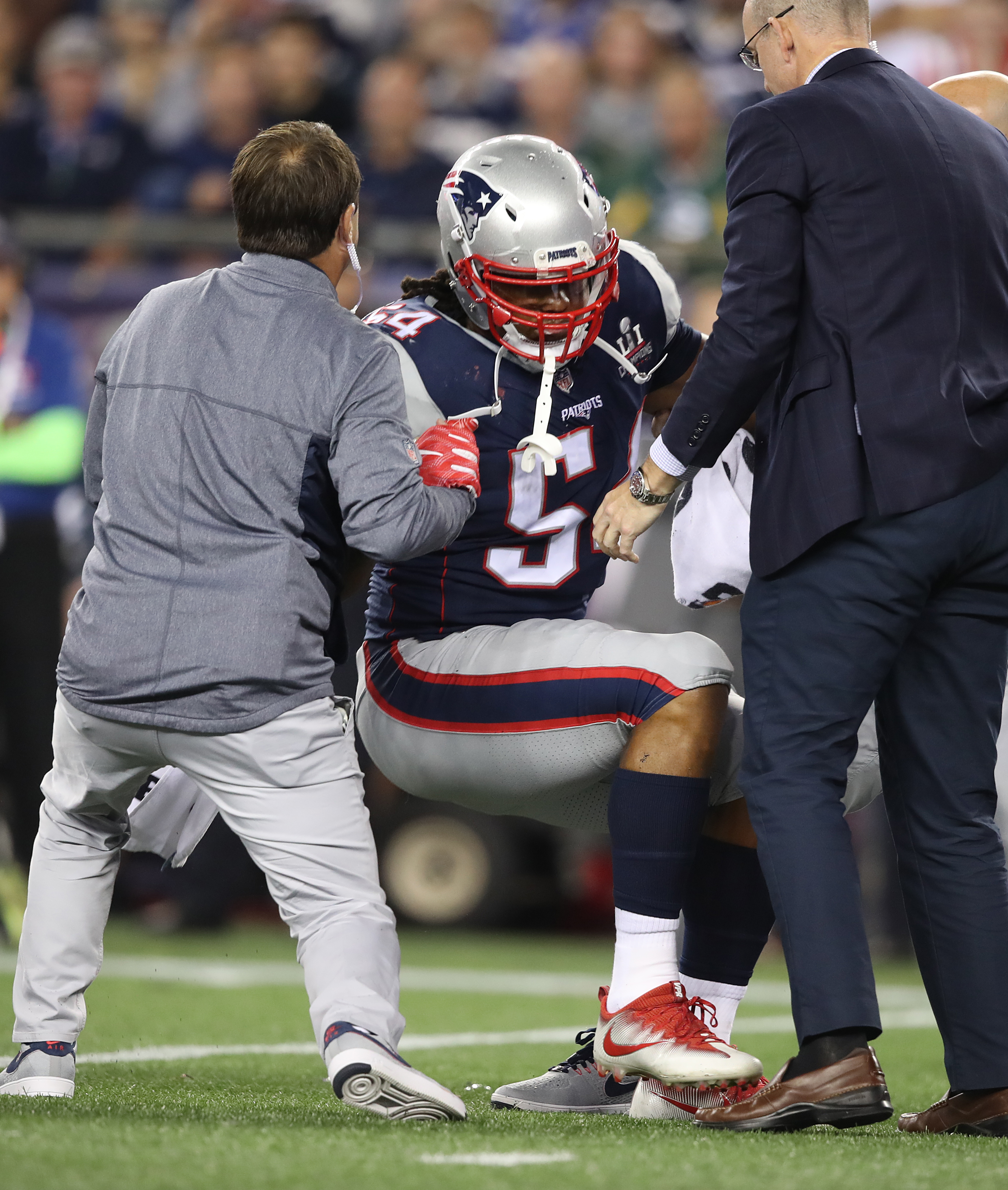 Llinebacker Dont'a Hightower is helped to his feet after he was injured in the second half.