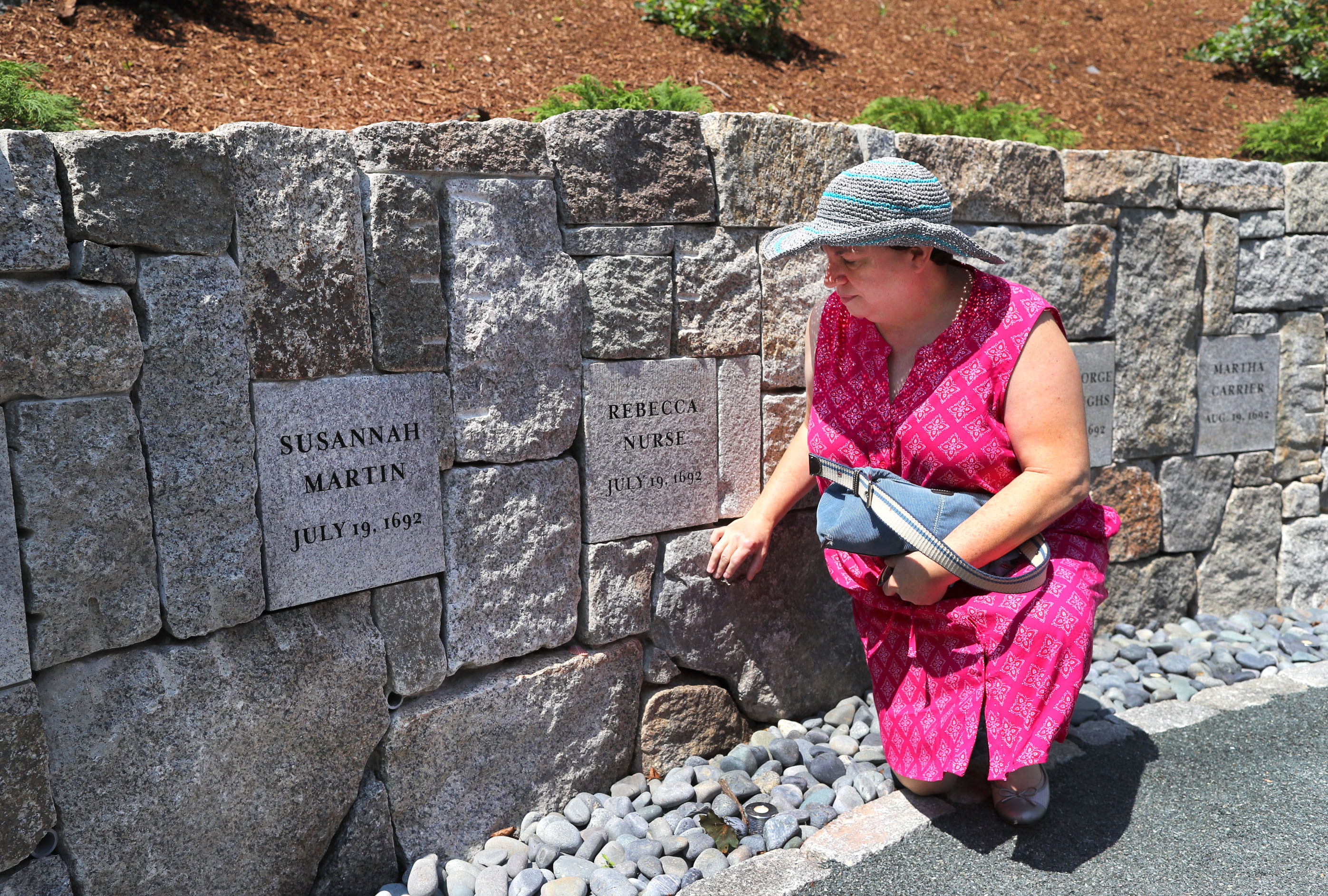 Benita Towle from Milford, Conn., stooped to touch the stone of executed witch, Rebecca Nurse, who was hanged on July 19, 1692. Towle is the seventh great-granddaughter of Nurse.