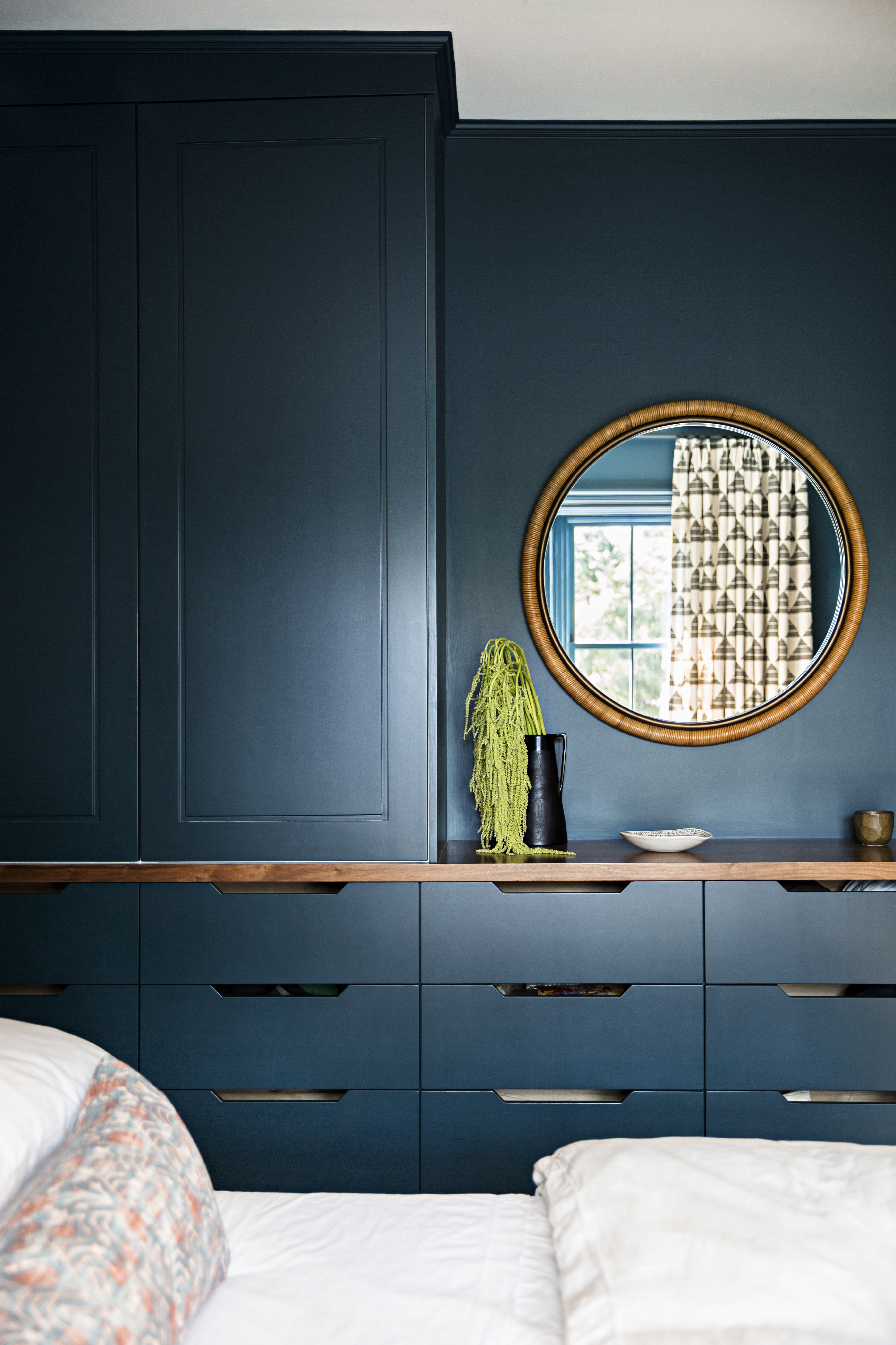A wicker-wrapped framed mirror from Pottery Barn matches the walnut top of new built-in cabinetry.
