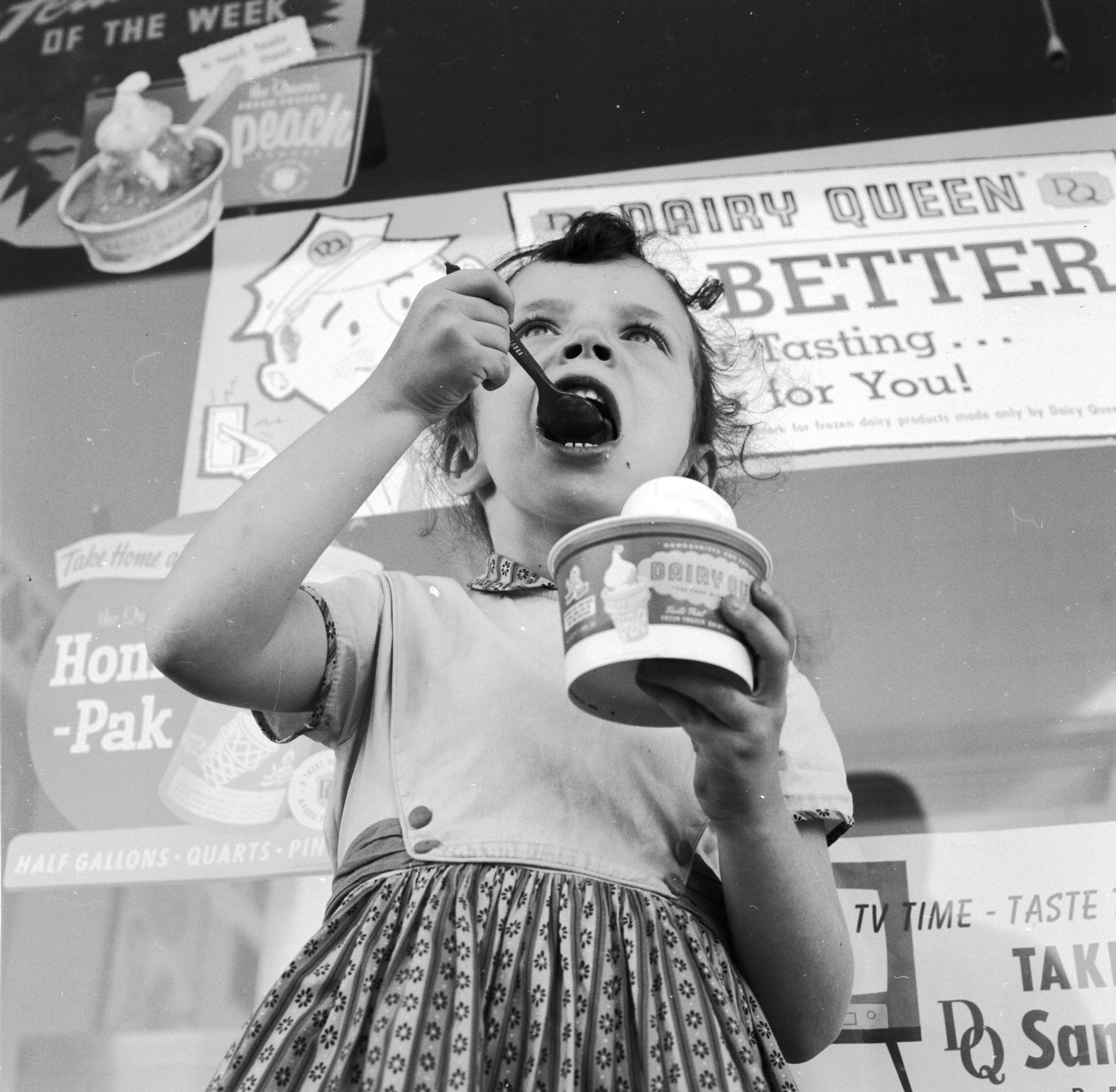 A young girl ate ice cream outside a Dairy Queen store in the 1950s.