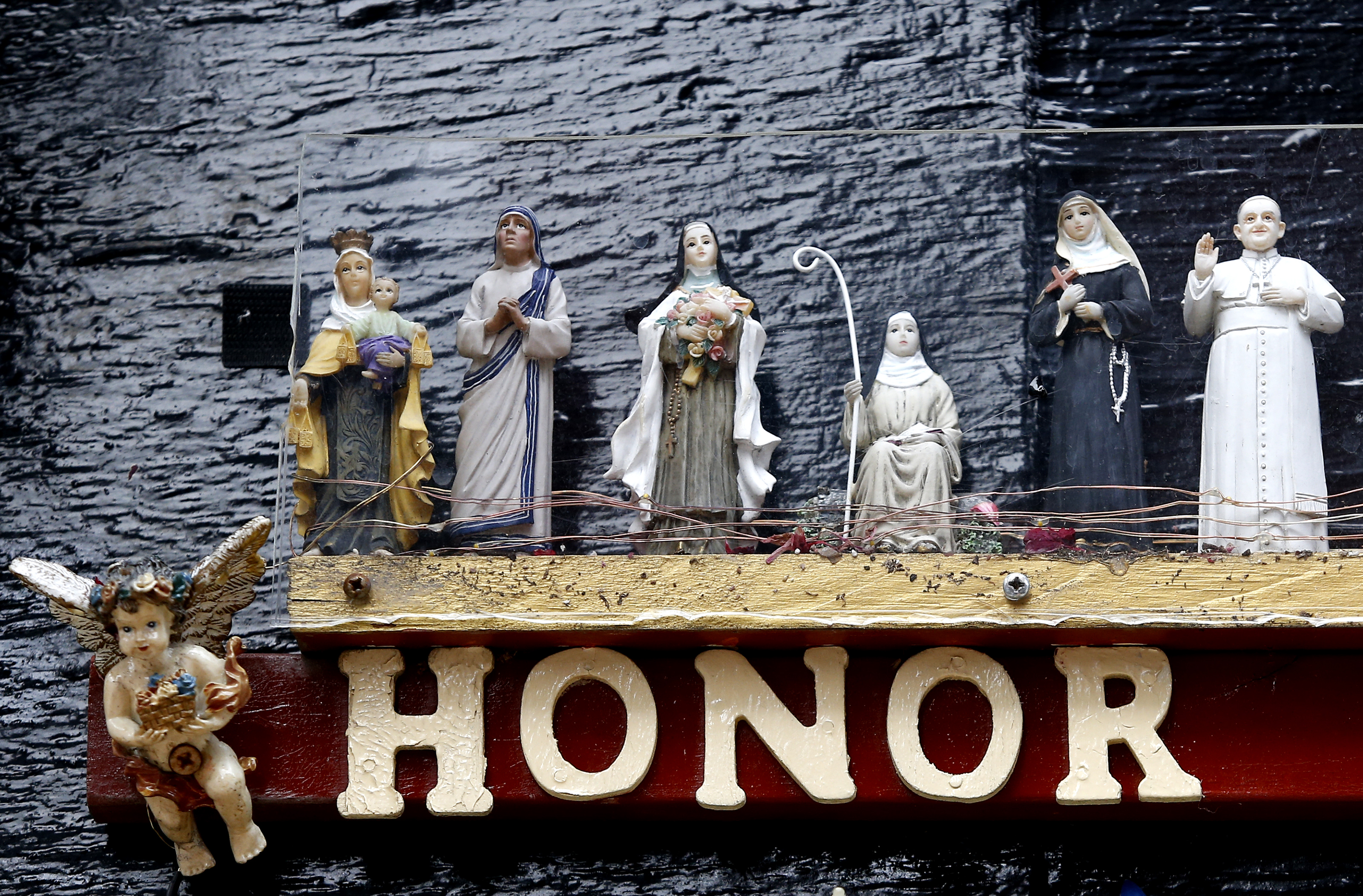 Statues of Catholic saints sit atop the entrance to All Saints Way, an alleyway.