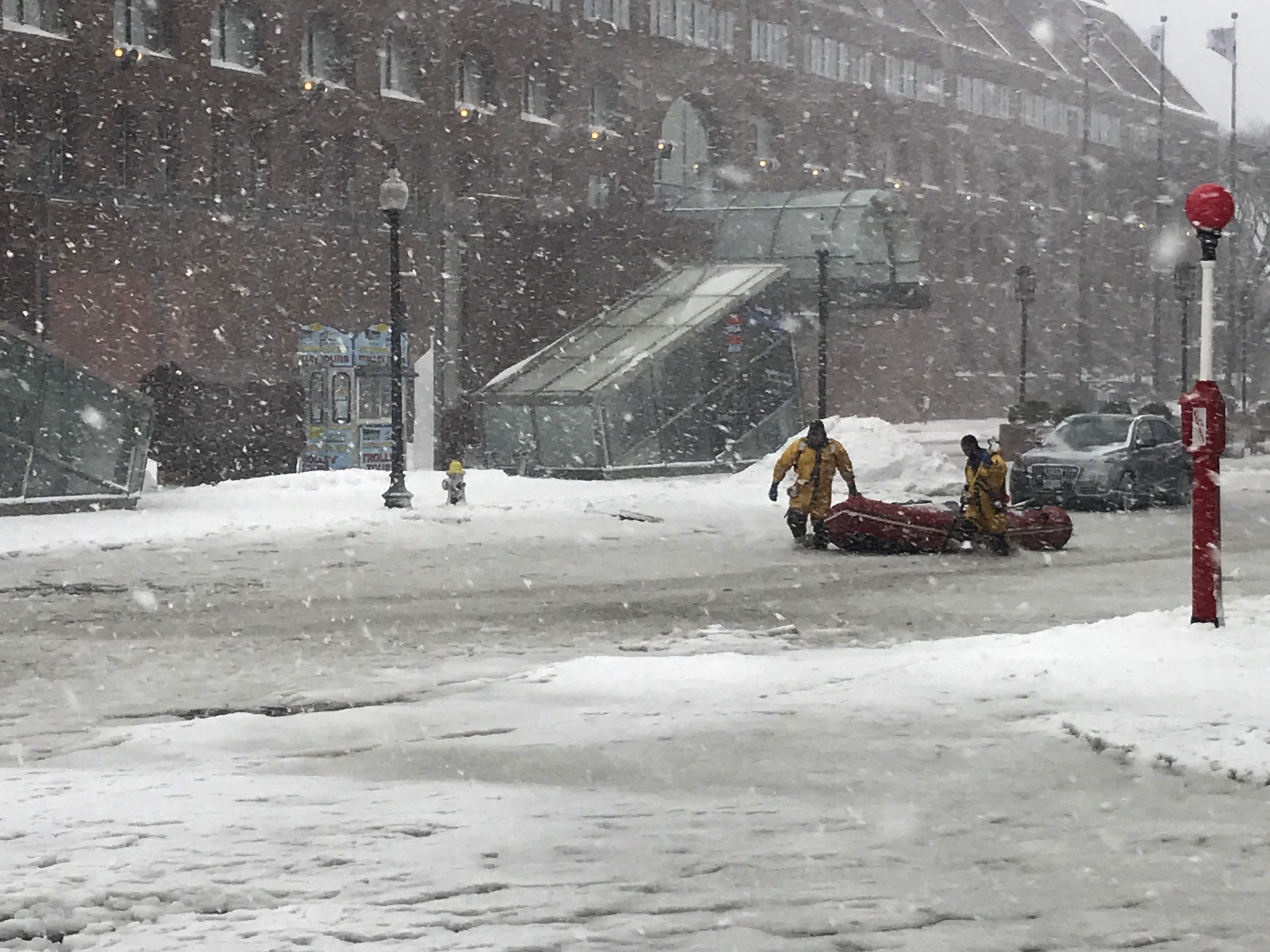 Boston firefighters waded through floodwaters from Boston Harbor in front of the Marriott Long Wharf hotel Thursday.