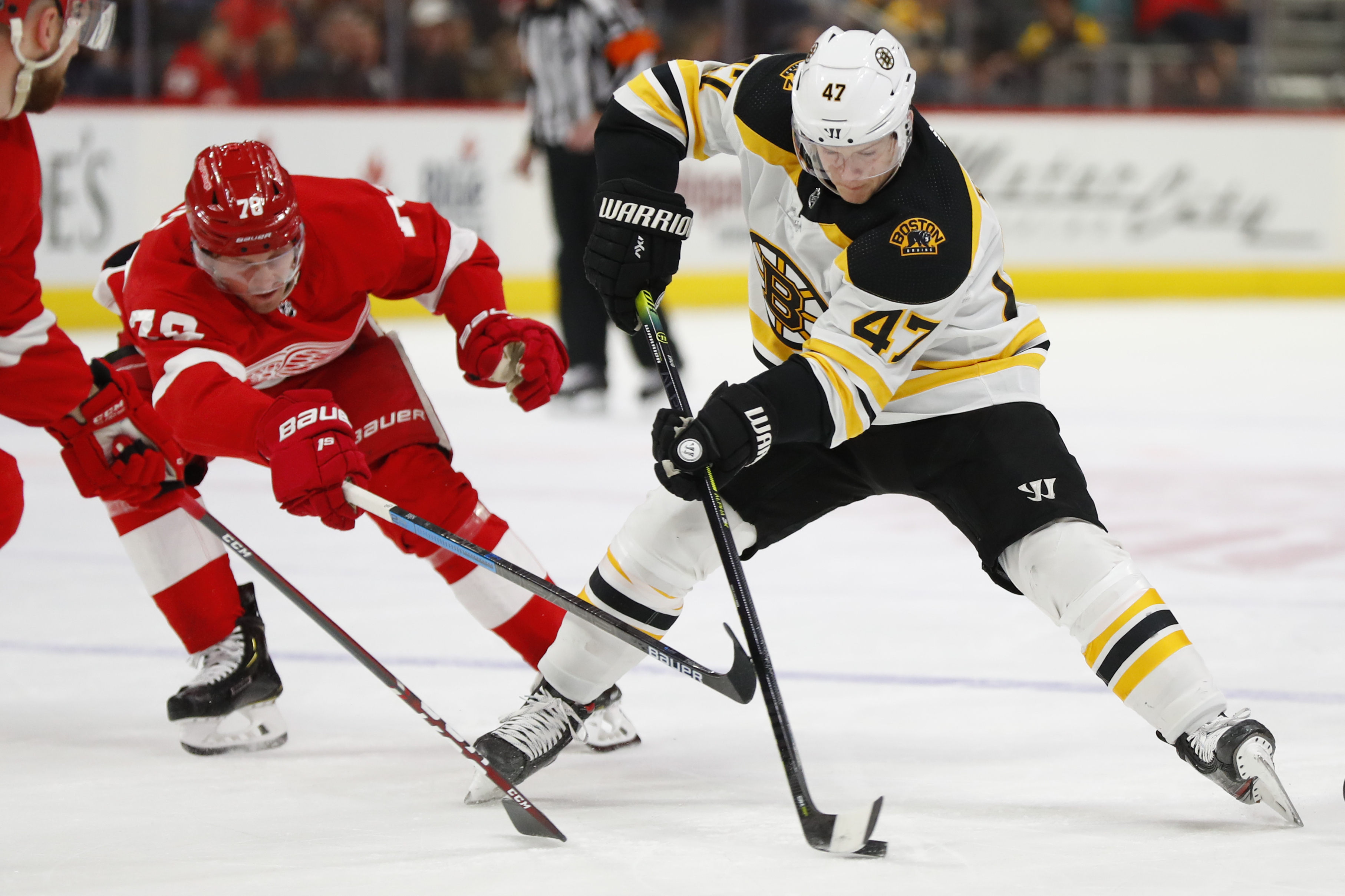 Torey Krug protects the puck from Detroit’s Christoffer Ehn in the first period of Sunday’s game.
