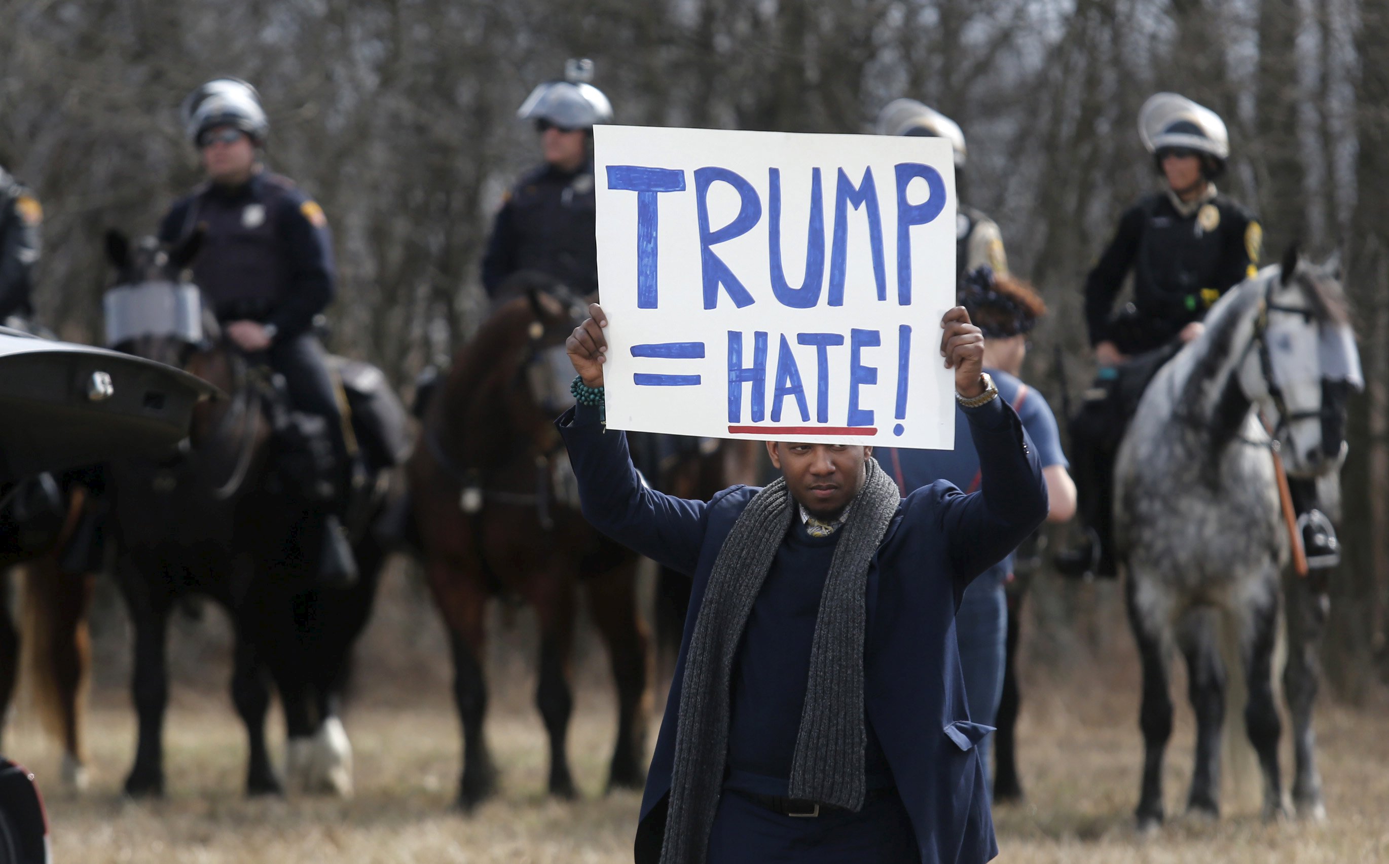 An anti-Trump protester held a sign in front of mounted police outside a Cleveland rally earlier this month.