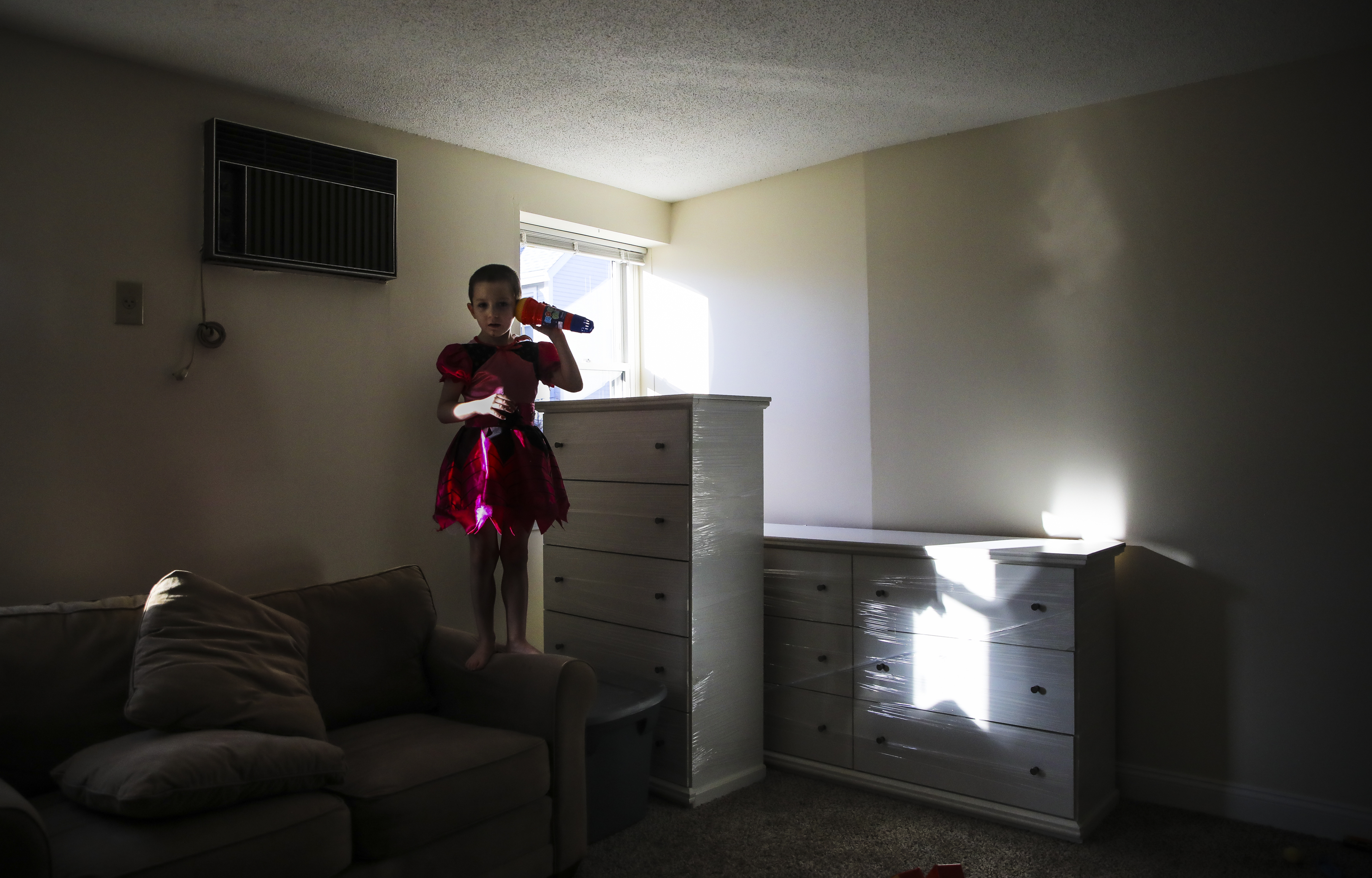 Dylan Lupien held a children’s microphone to his ear while he listened to the vibrations. Wrapped dressers rested next to him while his family began to fill their new apartment with the furniture that had been in storage for the past few months.