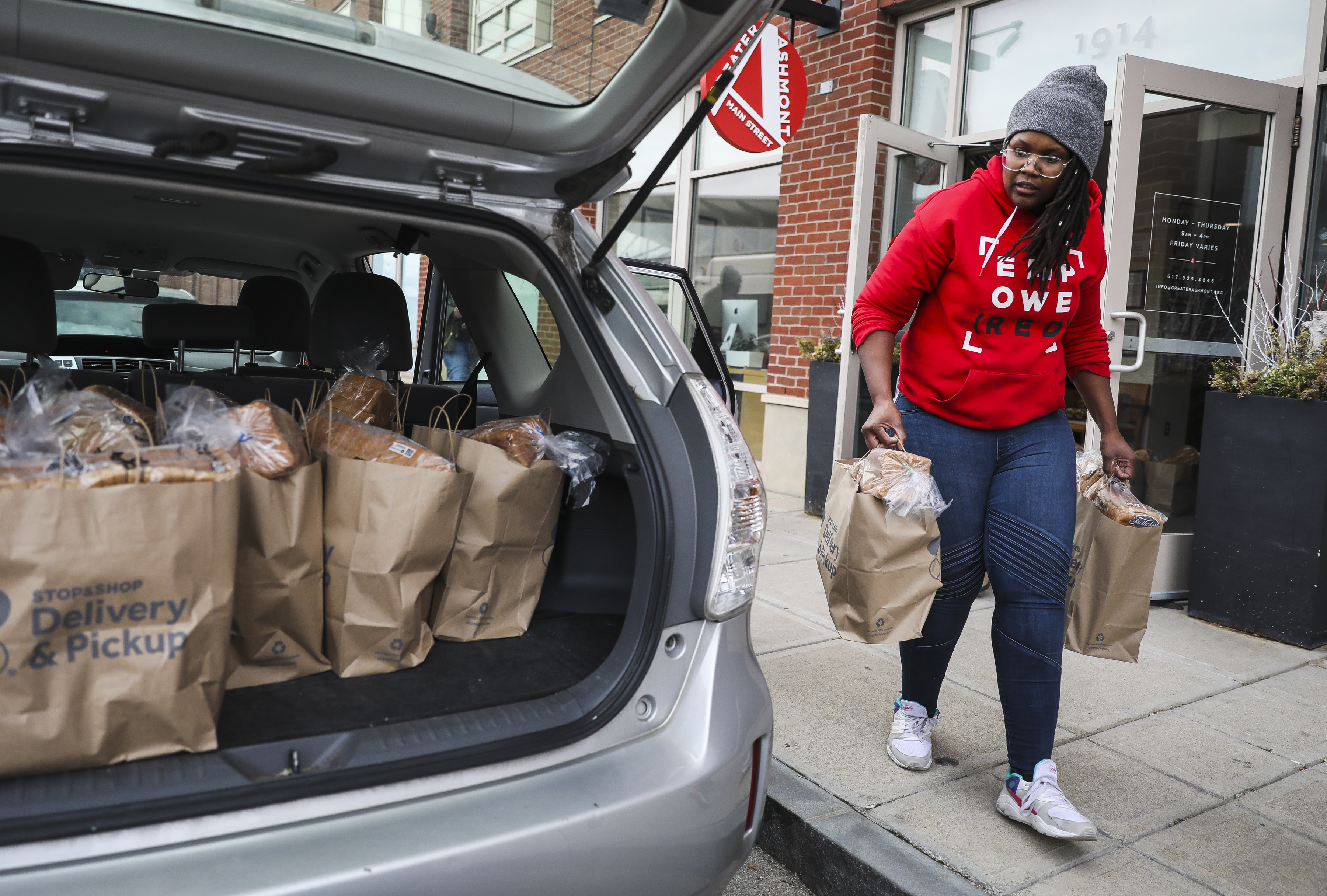 Joy Gary, program assistant and market manager for Greater Ashmont Main Street, loaded her car with food bags.