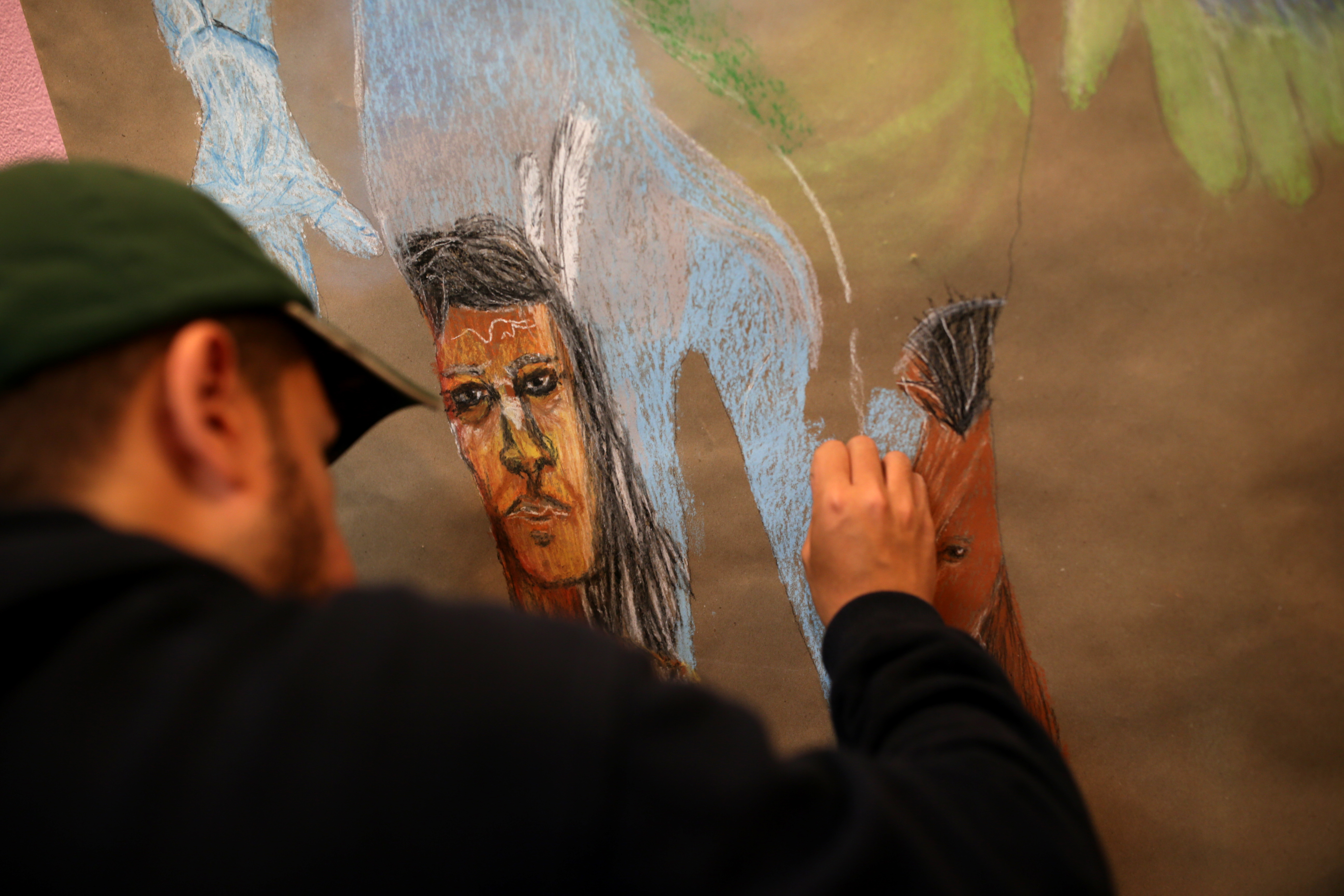 Benard Nina, 18, worked on a painting at the Urbano Project Gallery. (Jonathan Wiggs/Globe Staff)