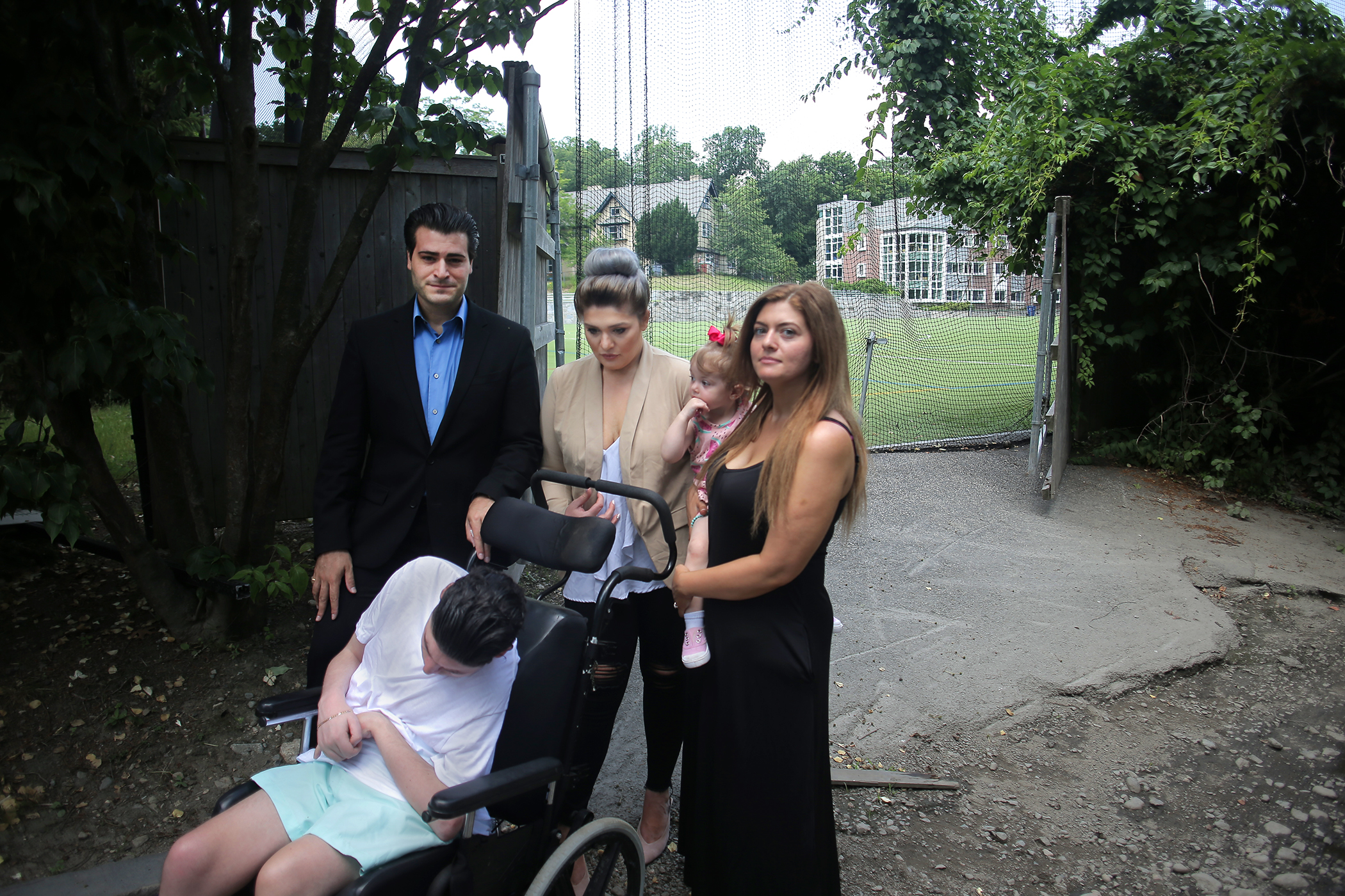 Dino Coppola (seated) with his siblings (left to right) Robert Earle-Coppola, Dominique Earle-Coppola, and Nancy Coppola (holding her daughter Gabriella Shnayder) near the Lasell College athletic field.