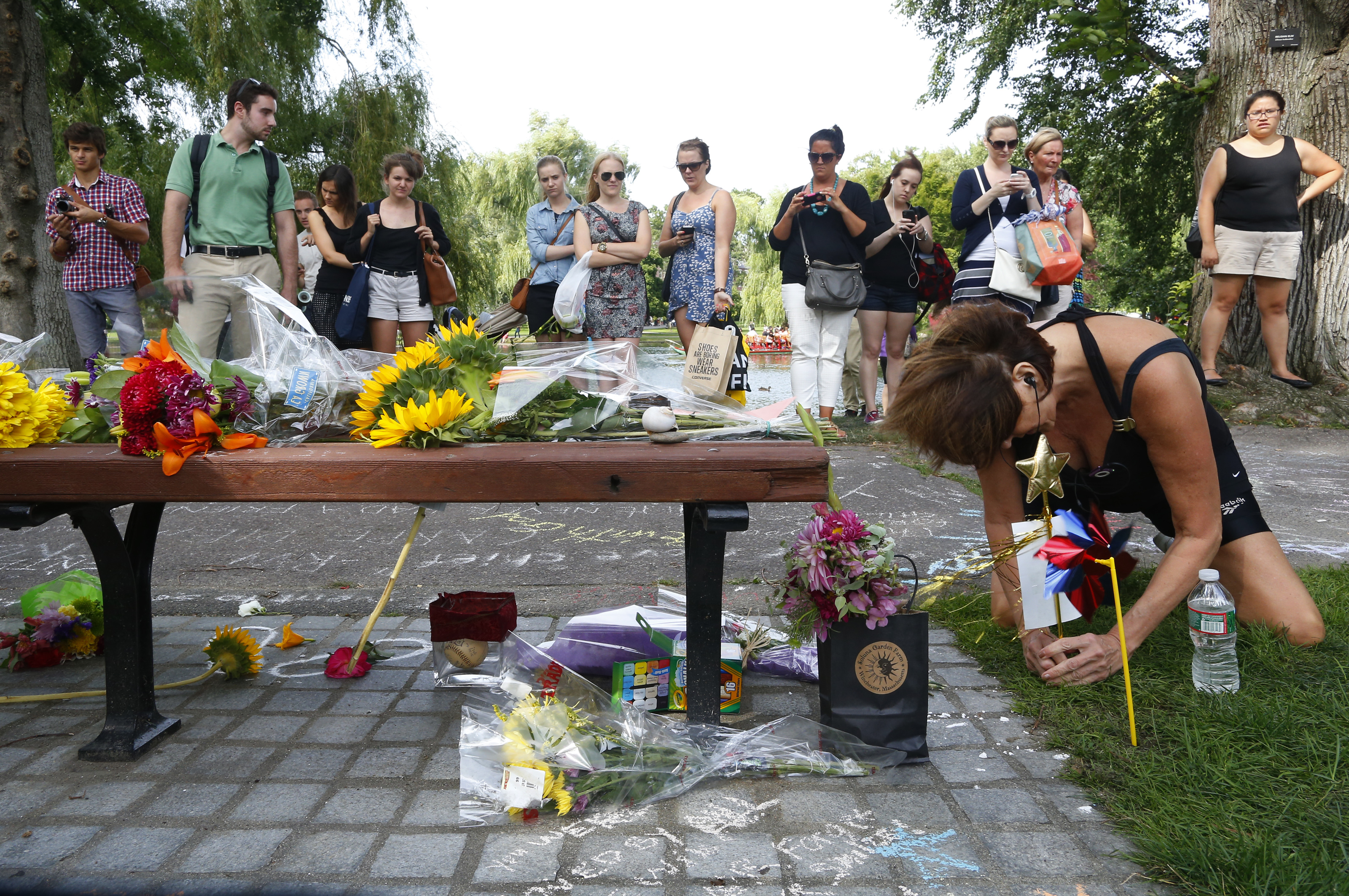 Mourners left bouquets of flowers on a bench in the Public Garden in tribute to actor Robin Williams.