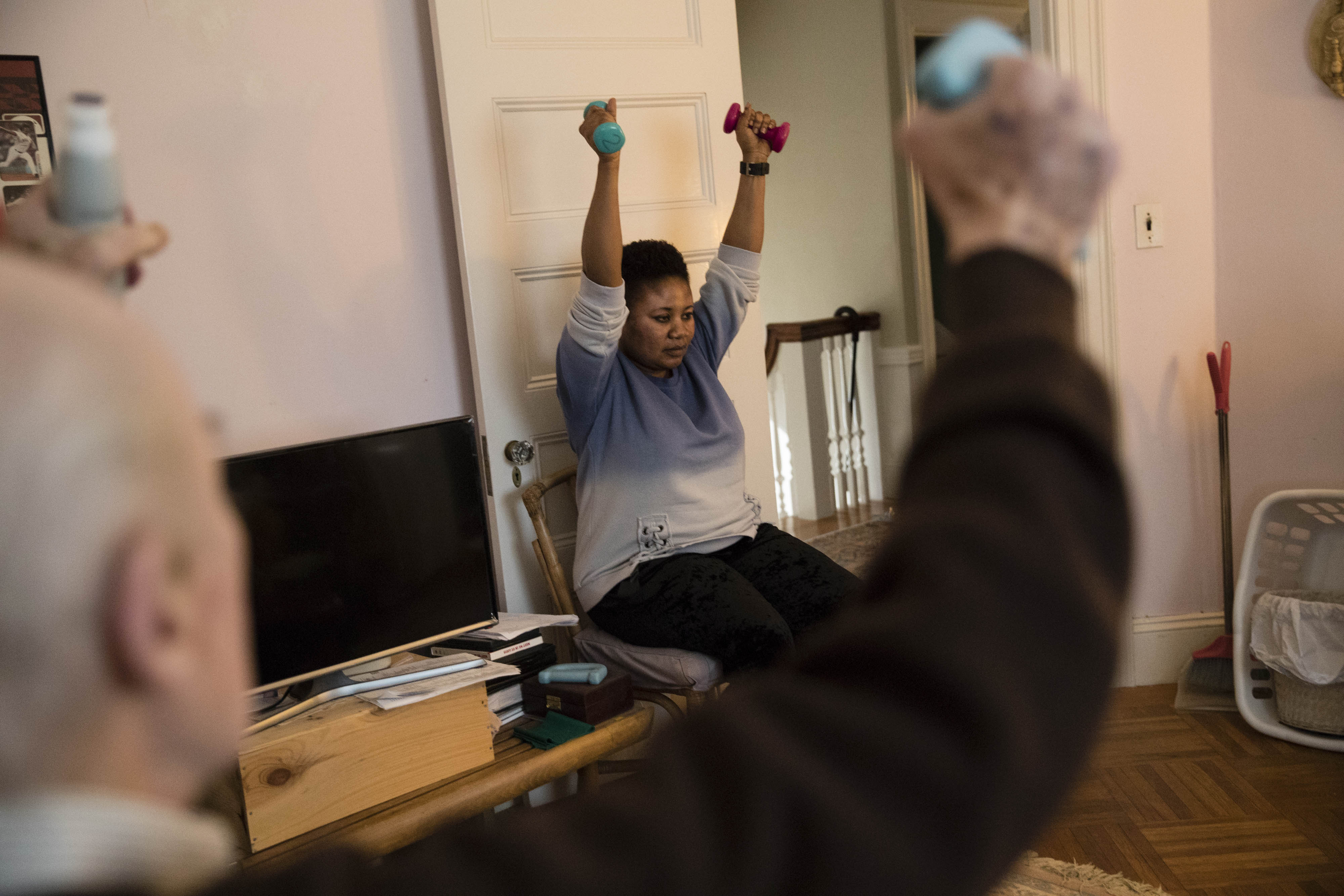 Sarpong guided her 90-year-old patient through morning exercises at his Newton home.