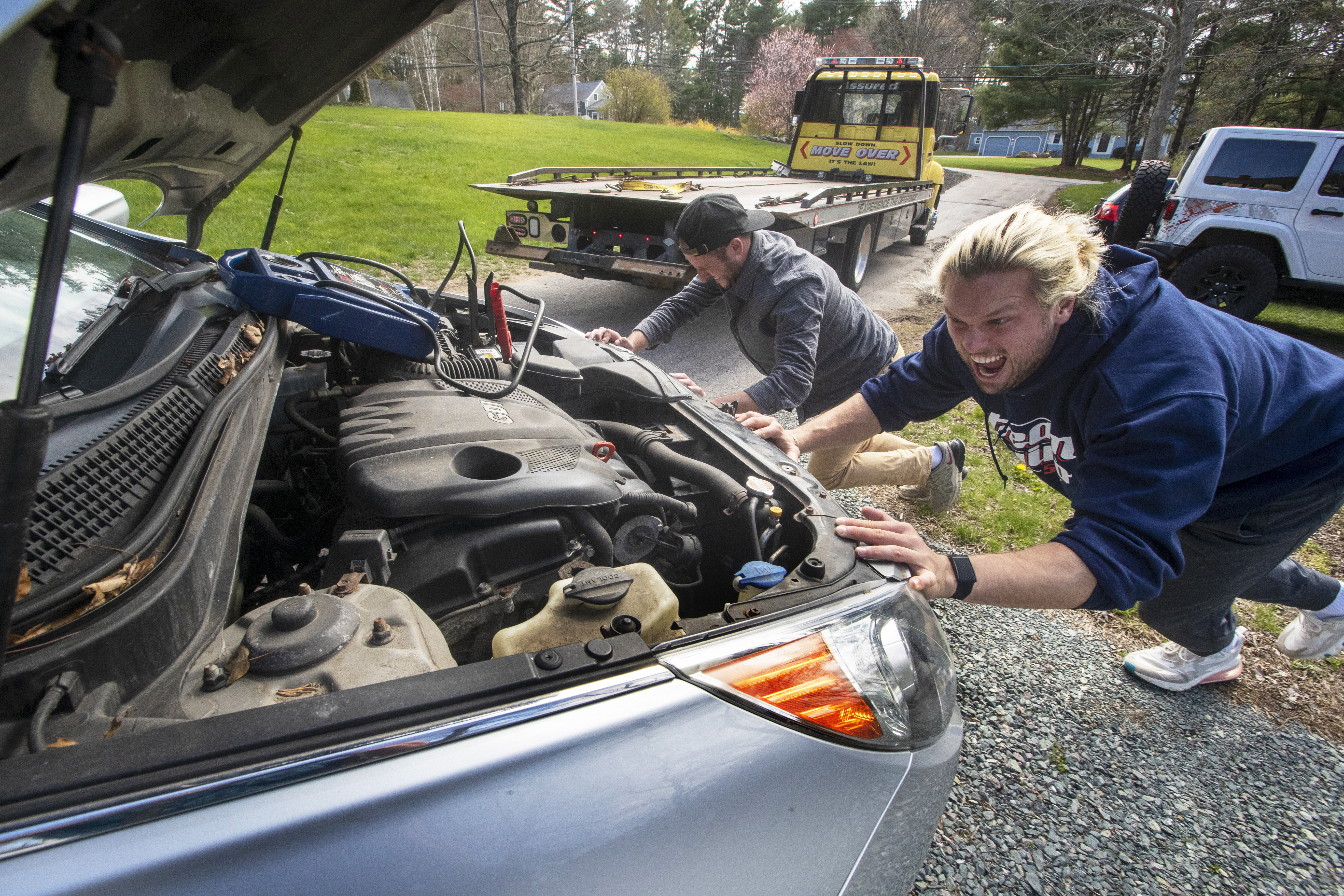 Winovich pushes his mother's car into a position to be removed from his driveway.