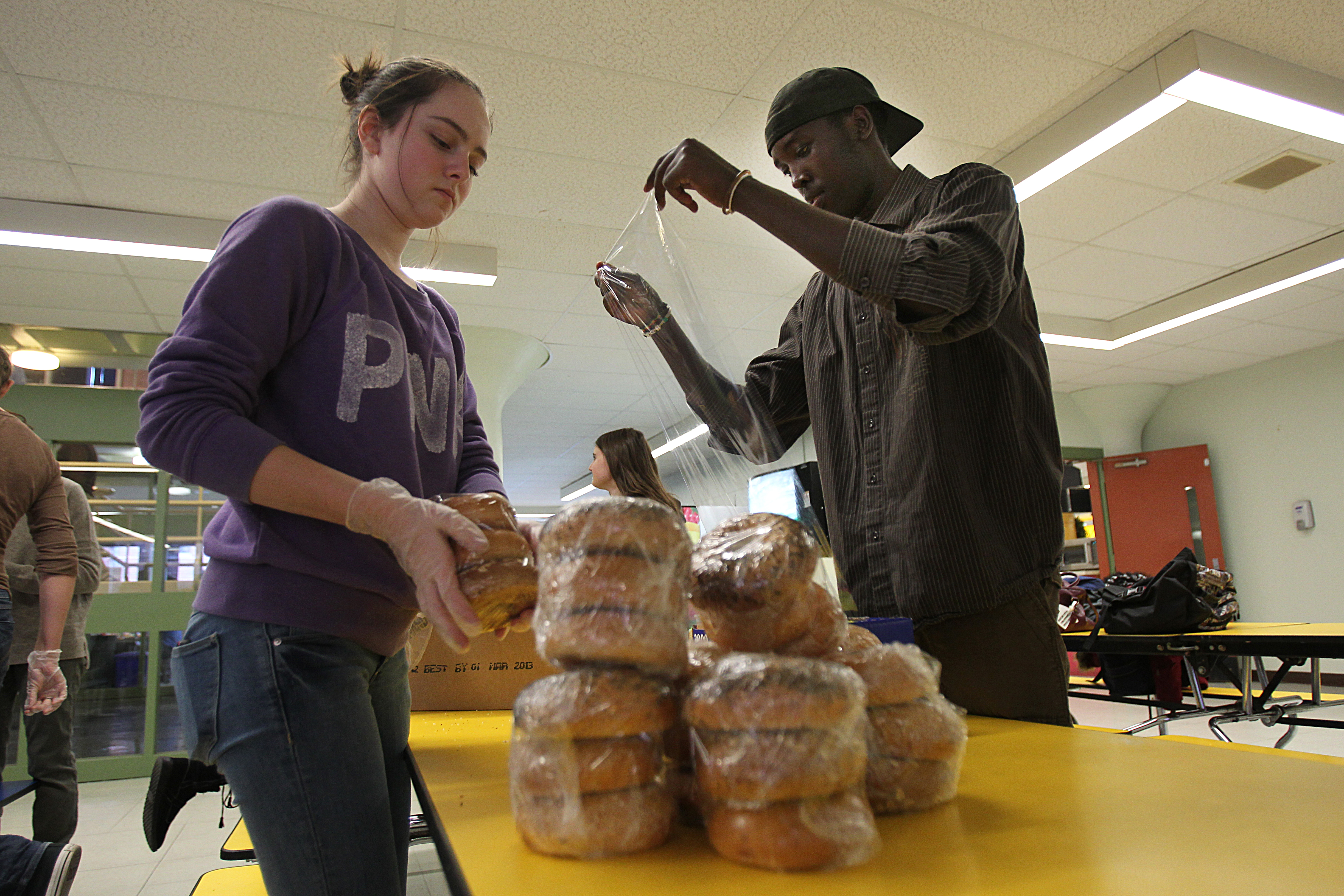 Samantha Dearing and Vincent Muhire wrapped Panera Bread leftovers for distribution at Menotomy Manor, an affordable housing development.