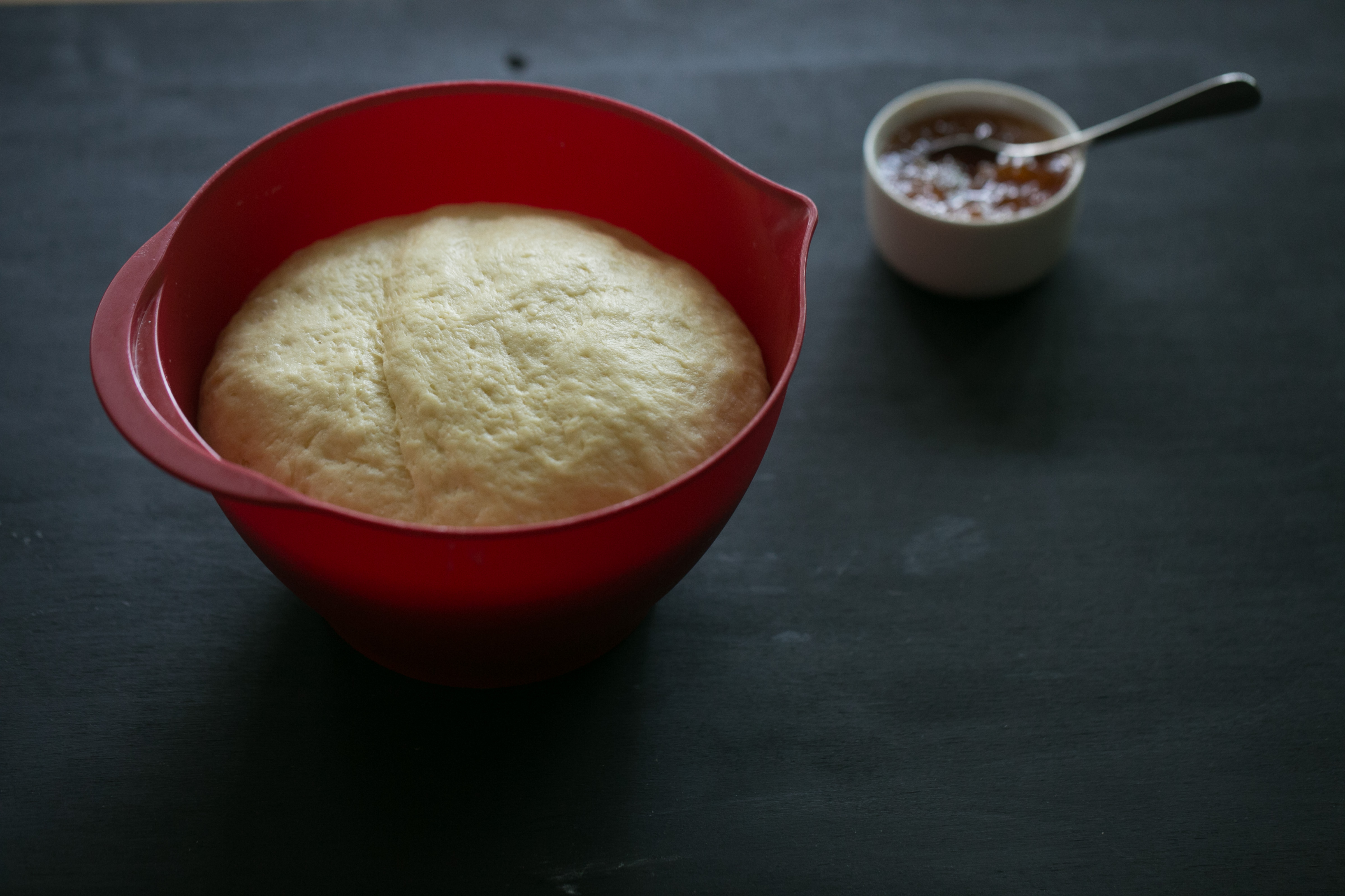 The dough rises in a mixing bowl.