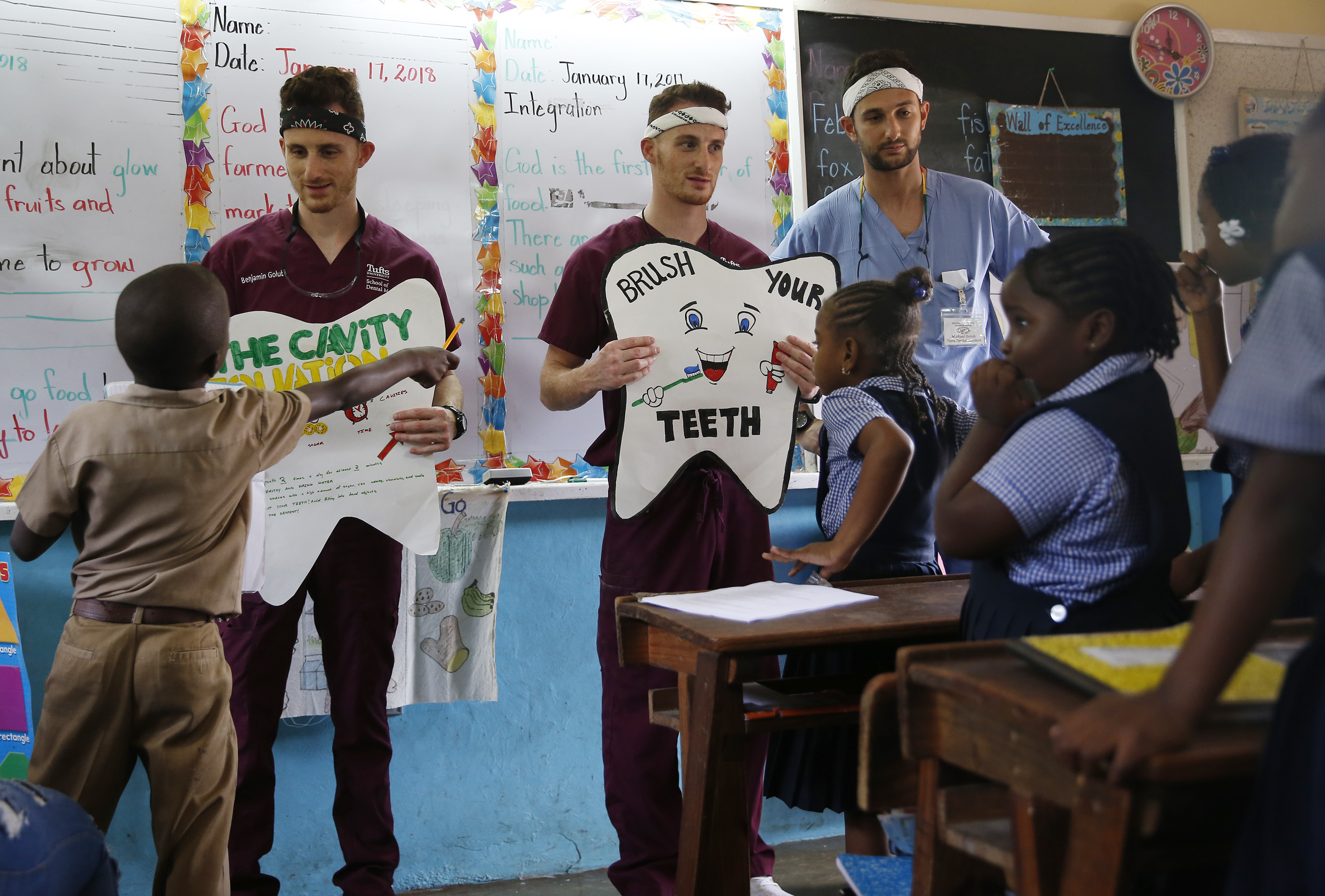 Students at Brown’s Town Primary School watched as (left to right) twin brothers Ben and Zachary Golub stood beside their older brother Michael during a session they spent teaching the class about dental hygiene. All three of the brothers are currently studying dentistry at Tufts.