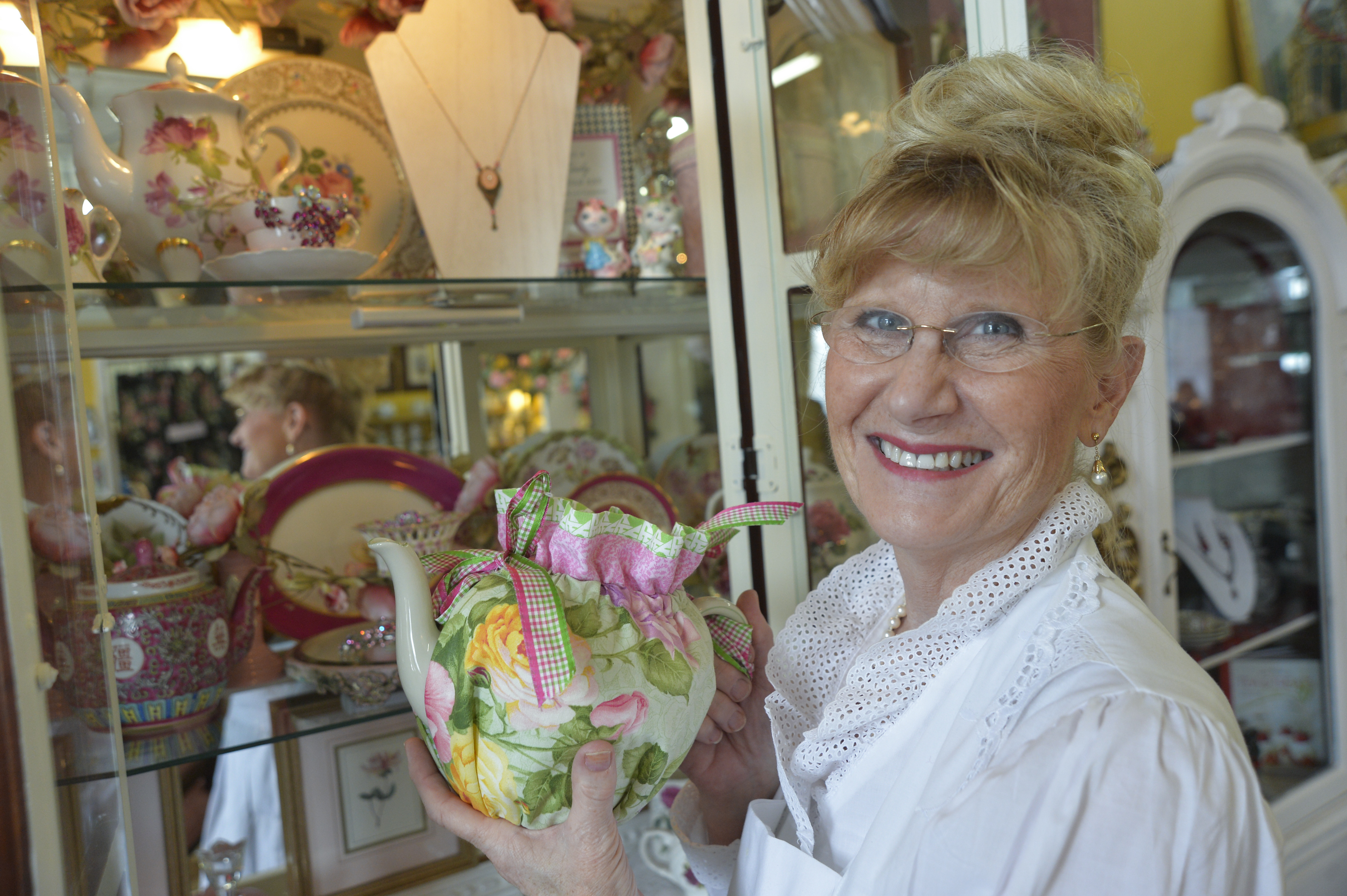 Owner Suzanne Richardson displays a brightly-colored teapot in her Lowell tearoom.