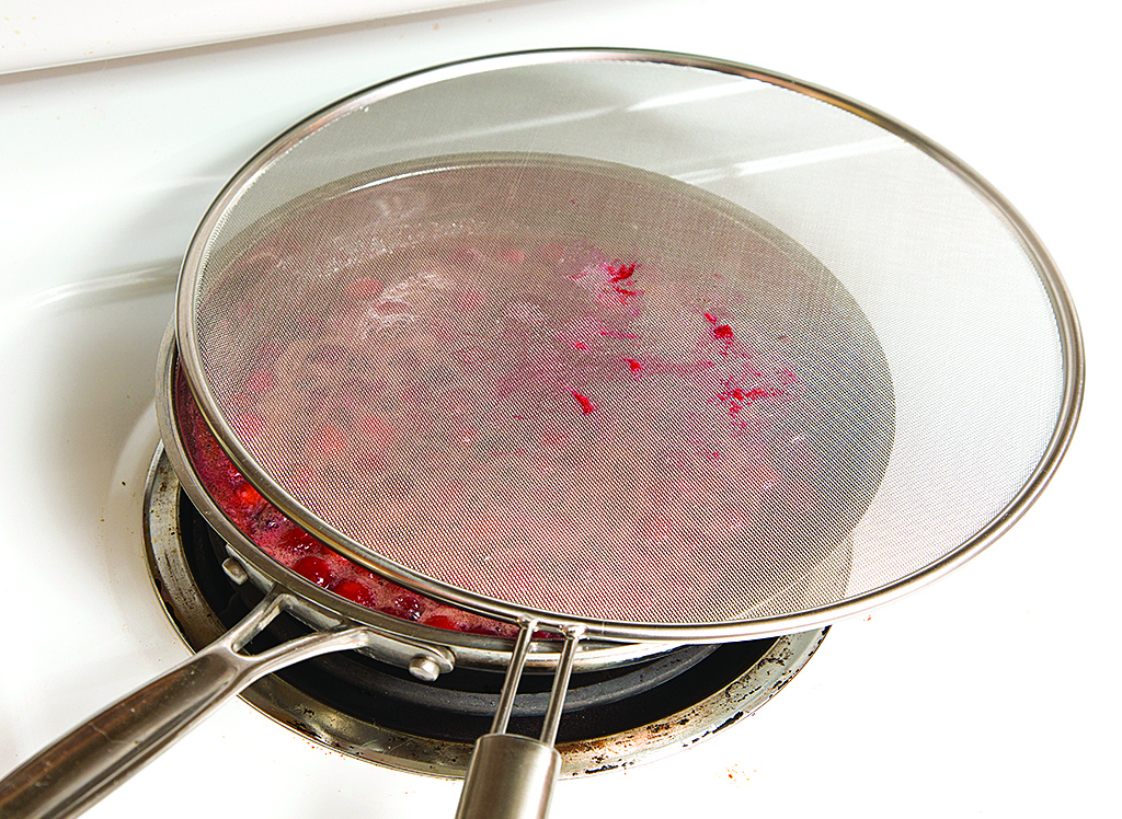 Cranberries pop as they cook and split open, which can launch drops of whatever liquid they’re cooking in. My solution? I use a splatter screen to keep the hot liquid in the pan and off my body.