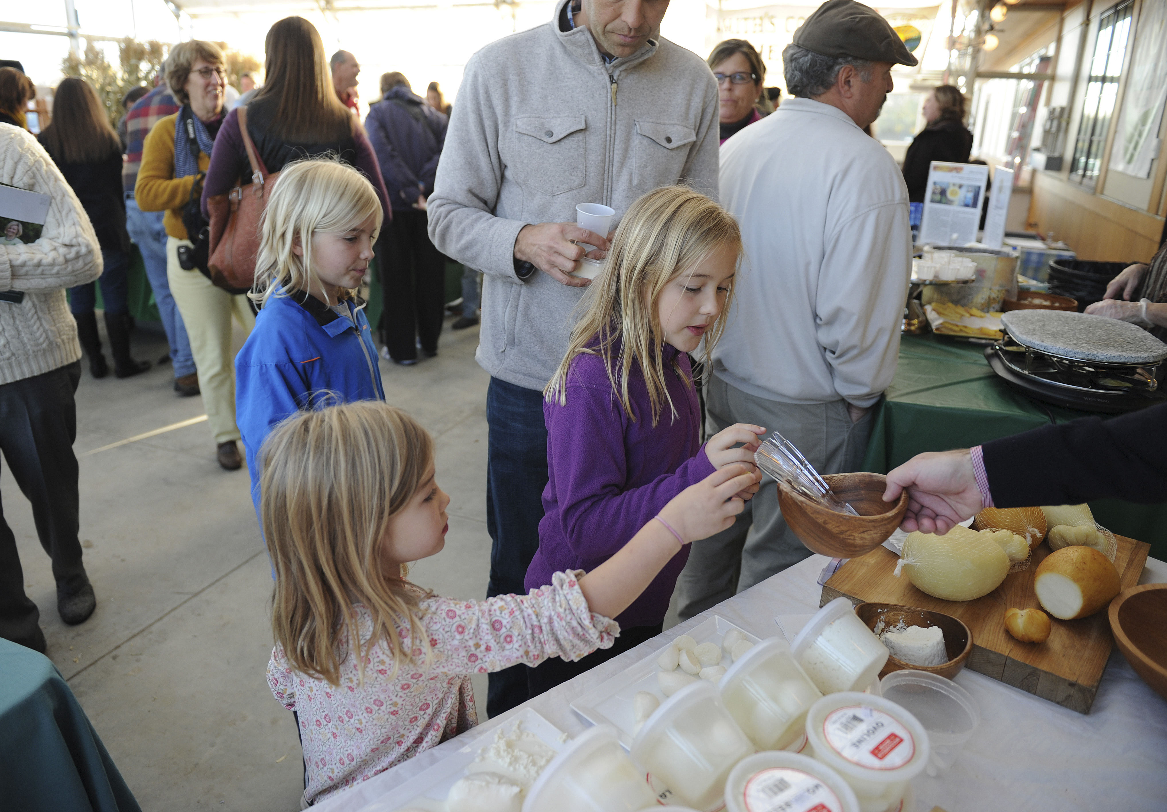 The Noordzij sisters — Colette, 9, Fiona, 5, and Sydney, 7 — enjoy samples from the Mozzarella House table.