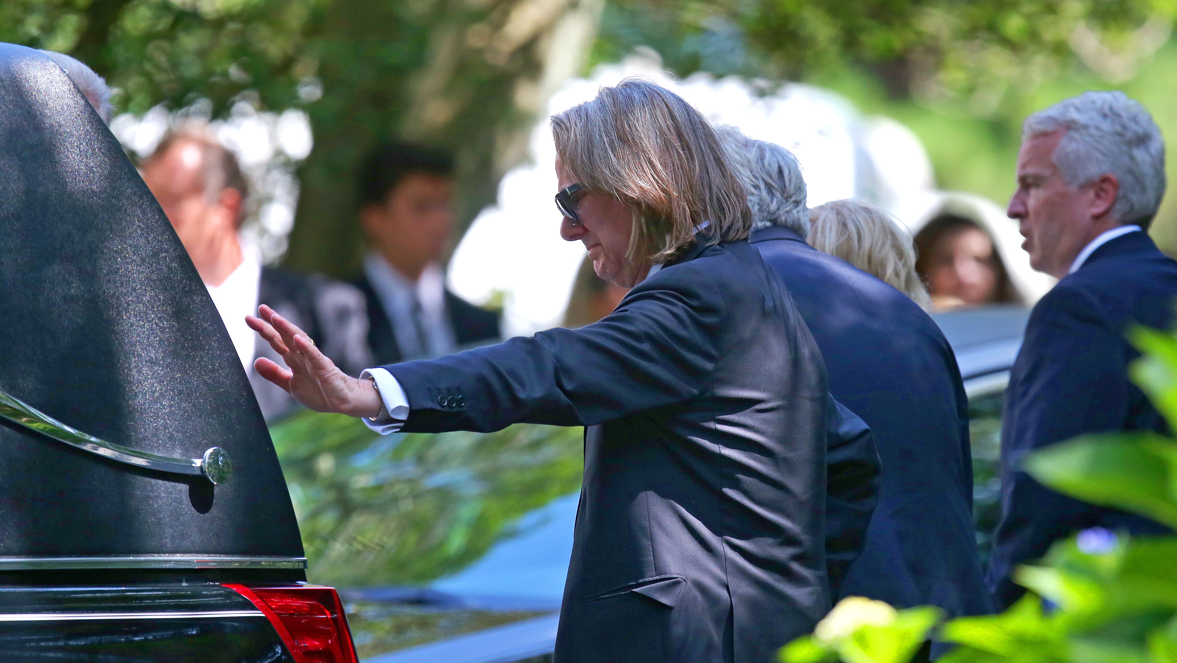 Saoirse's father, Paul Michael Hill, placed his hand on the hearse carrying his daughter.