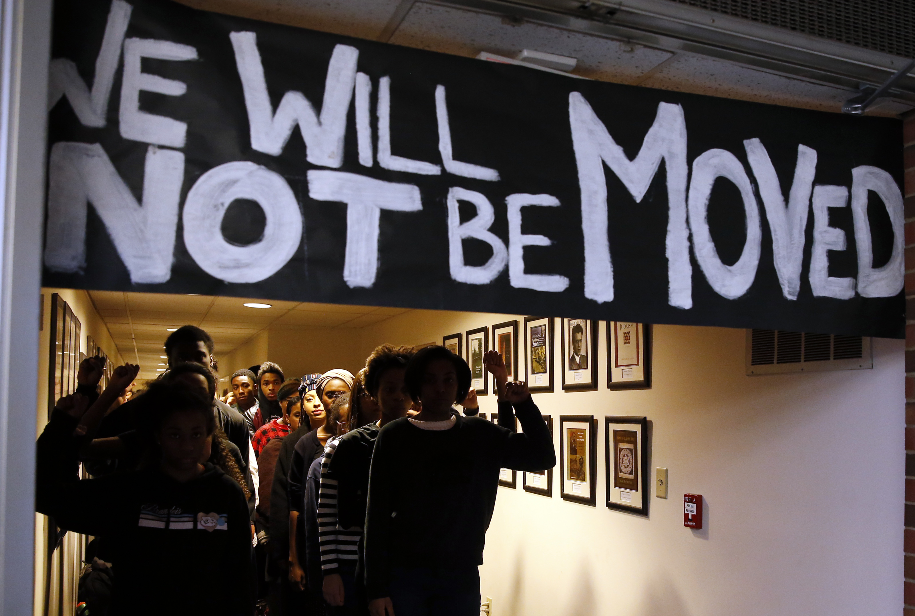 A banner hung in the hallway being occupied by students.