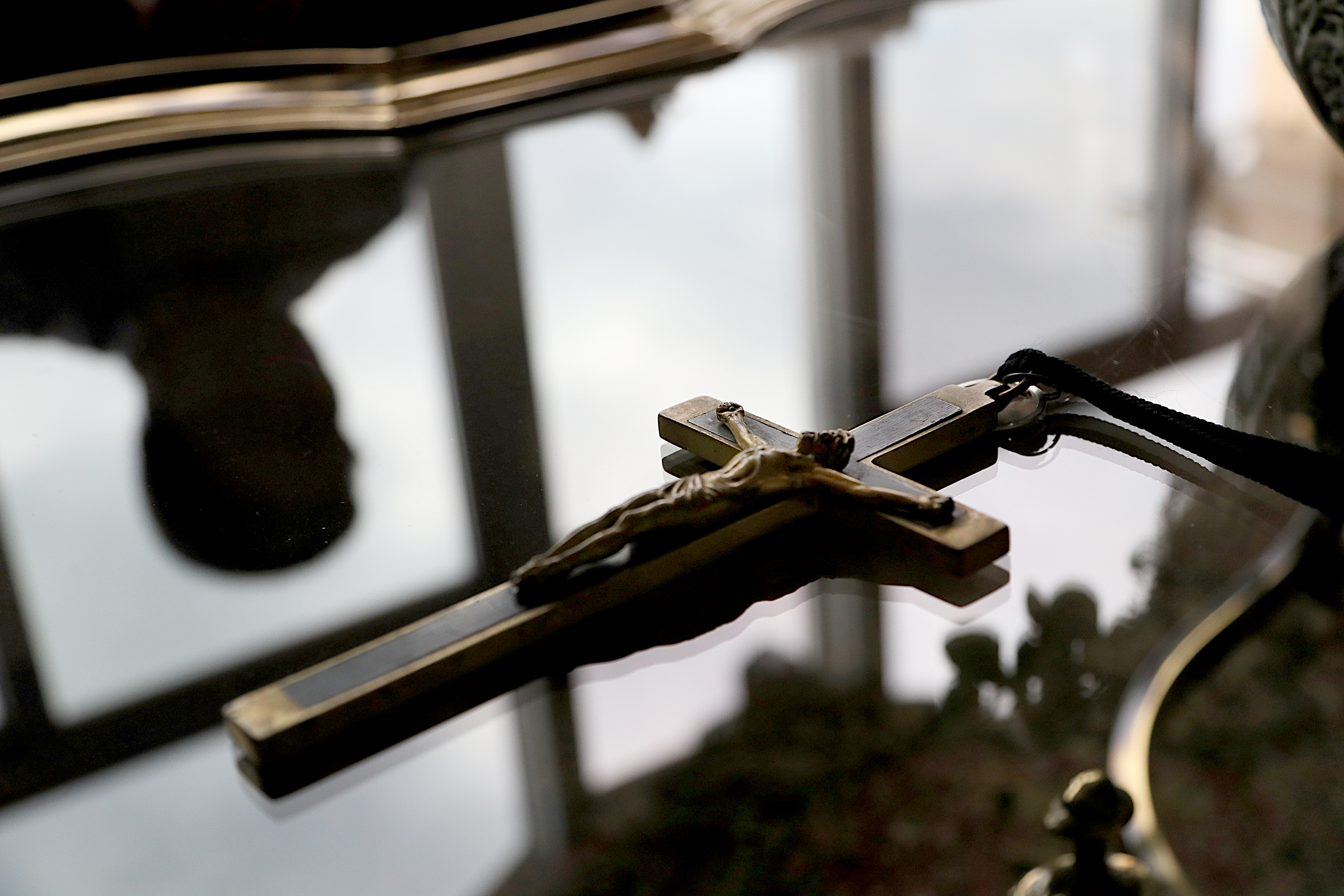 Jim Graham, who believes he is the son of a Catholic priest, in his home with his father's crucifix on the table.