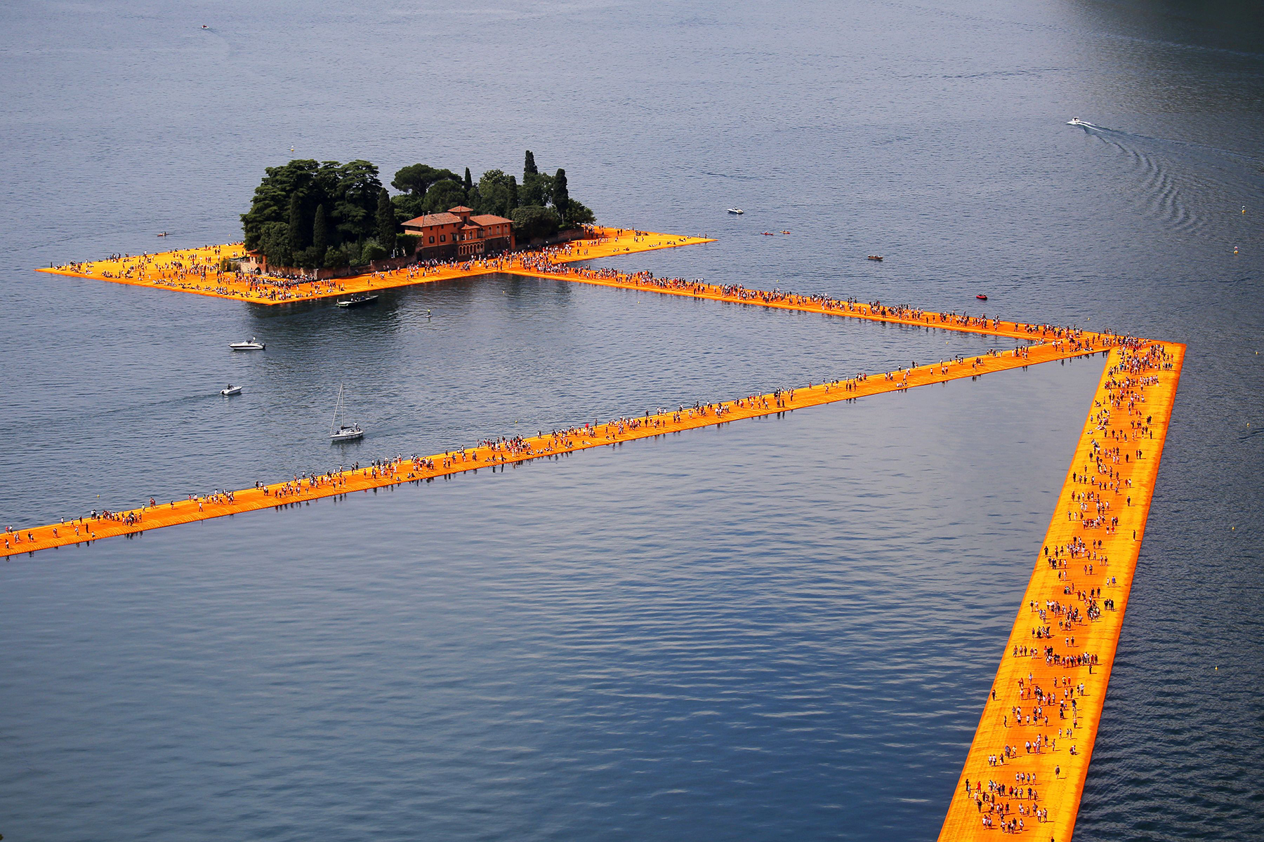 People stroll atop The Floating Piers, a 2-mile-long temporary installation by artists Christo and Jeanne-Claude, erected on Lake Iseo last summer.