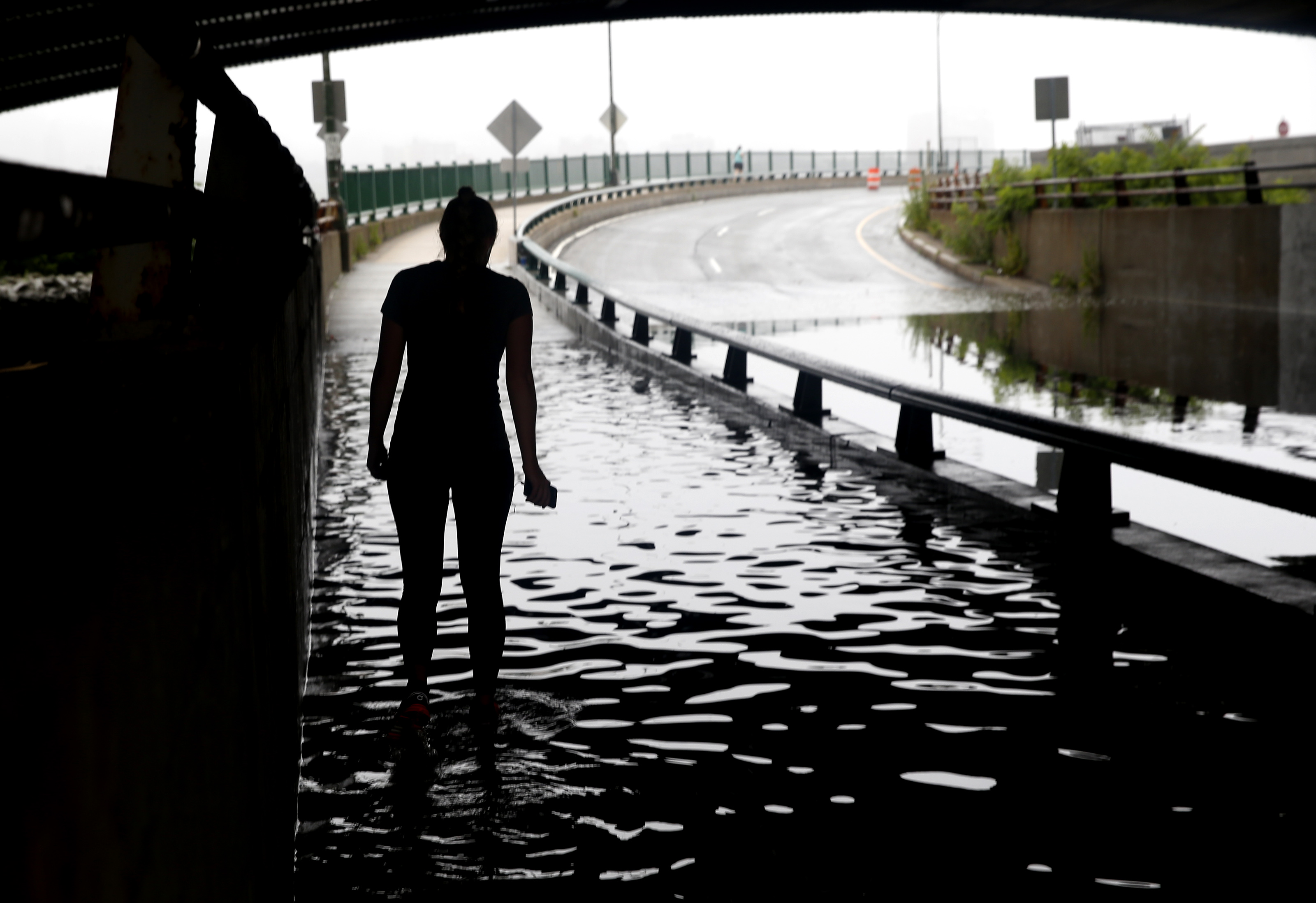 A runner tried to run through a flooded section of Memorial Drive in Cambridge that passes under the Longfellow Bridge.