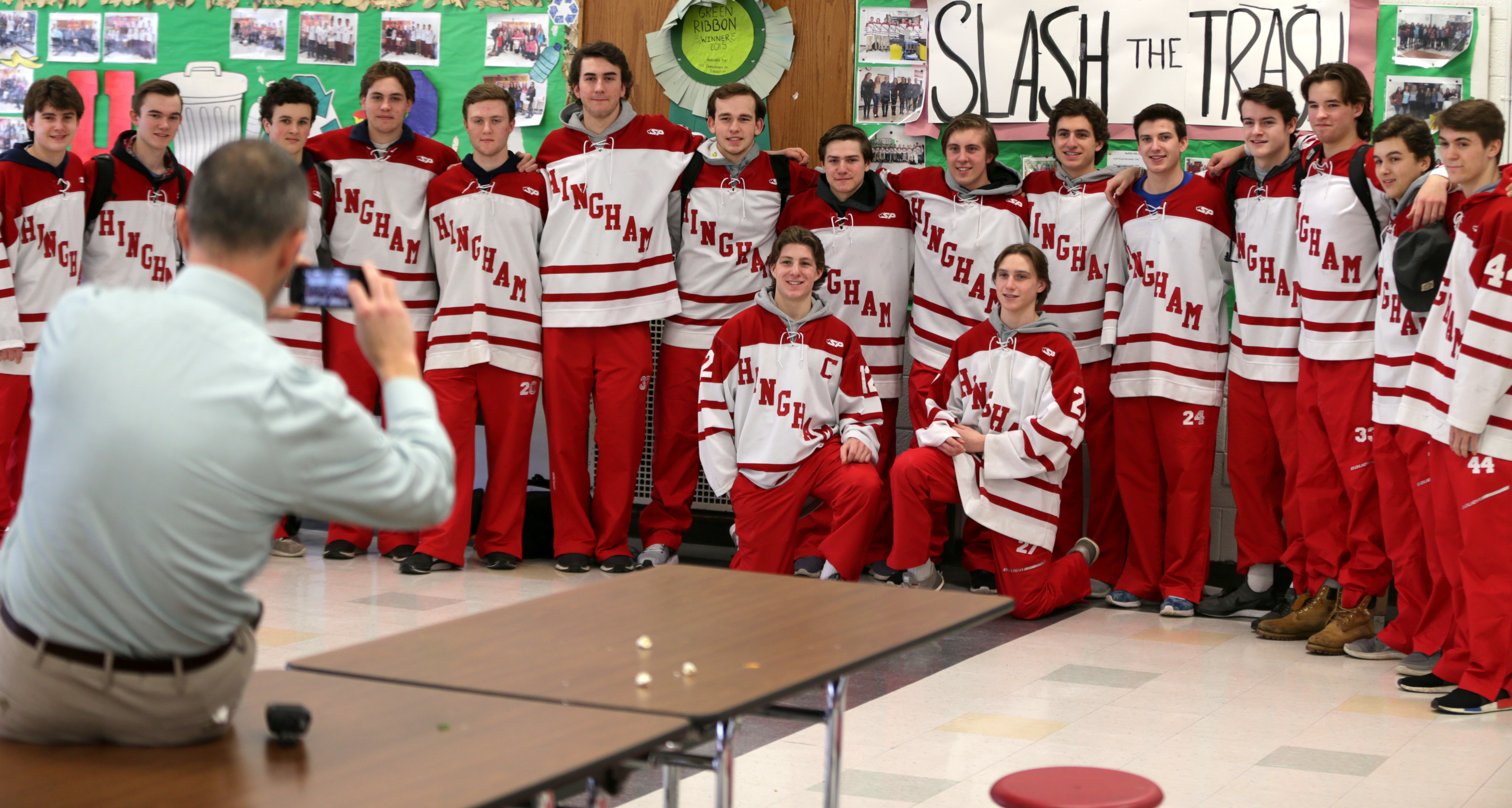 Hingham High School principal Rick Swanson took a photograph of the hockey team after its “Slash the Trash” session in the school caferteria in January.