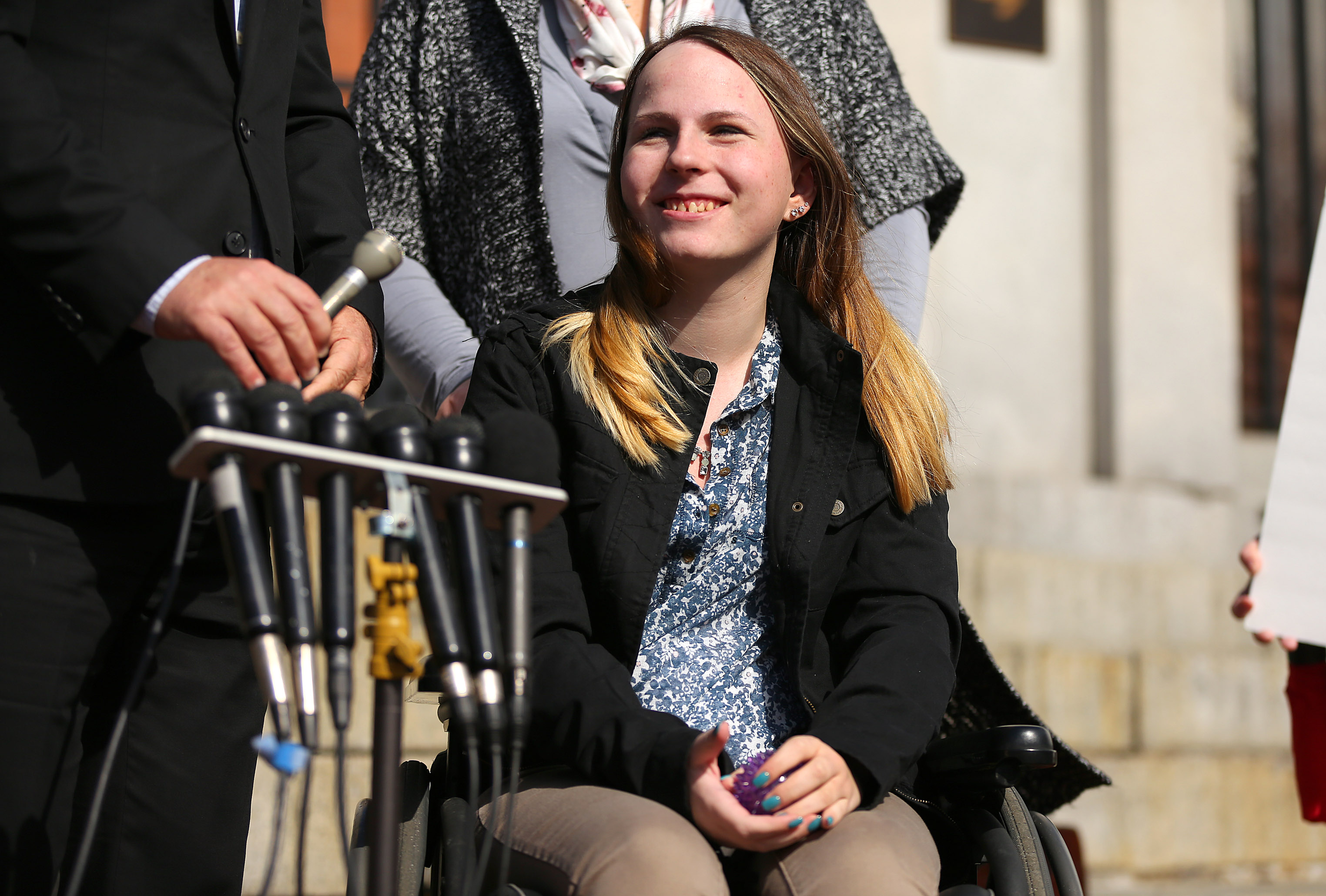 Justina Pelletier smiled as she listened to reporters’ questions in front of the State house Thursday with her parents, Linda and Lou.