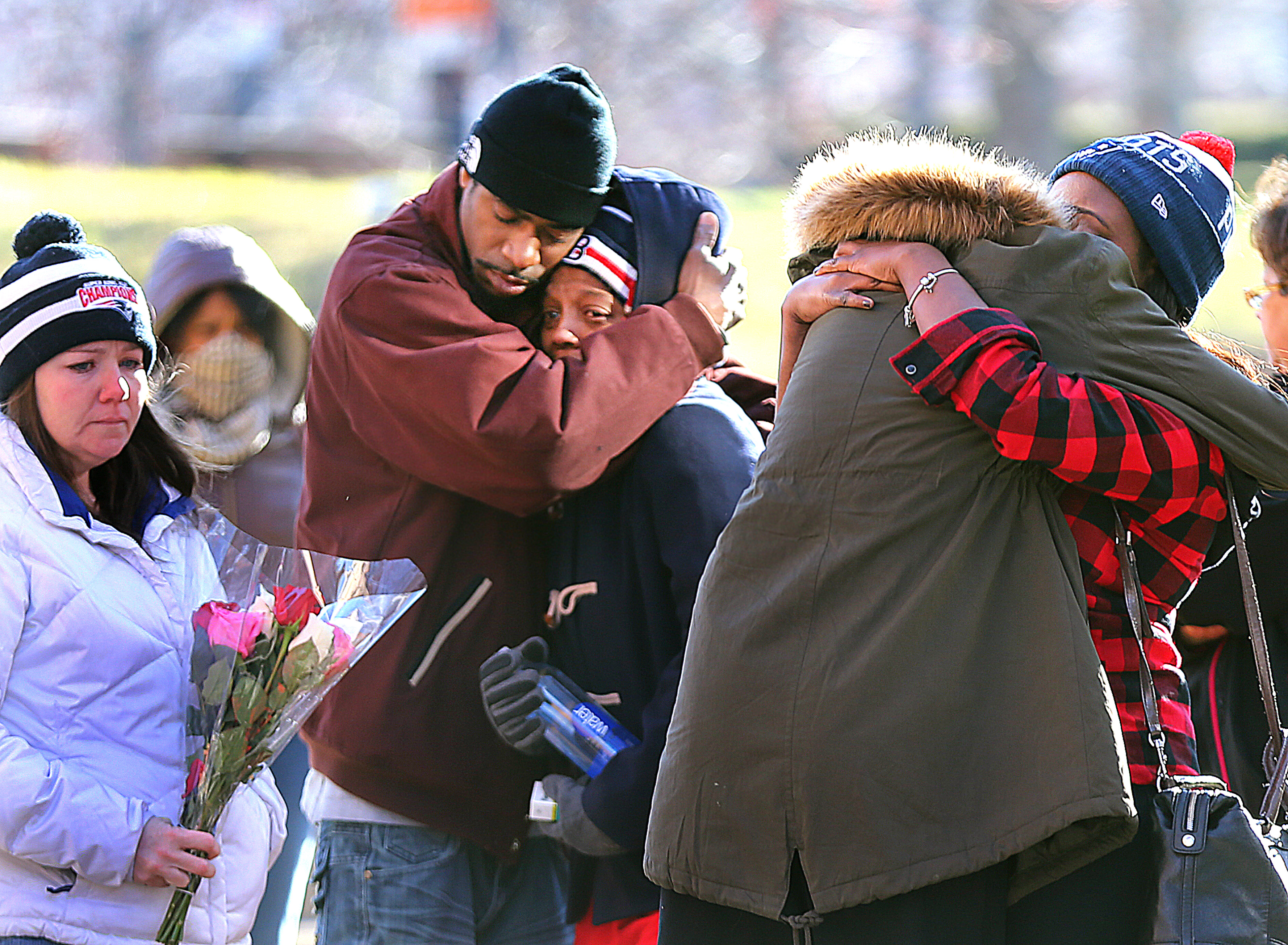 Seventeen-yr-old D'Andre King-Settles was shot and killed on Annunciation Road as his mother, Lawanda Settles, left, is comforted at a makeshift memorial of candles on the ground near the shooting scene.