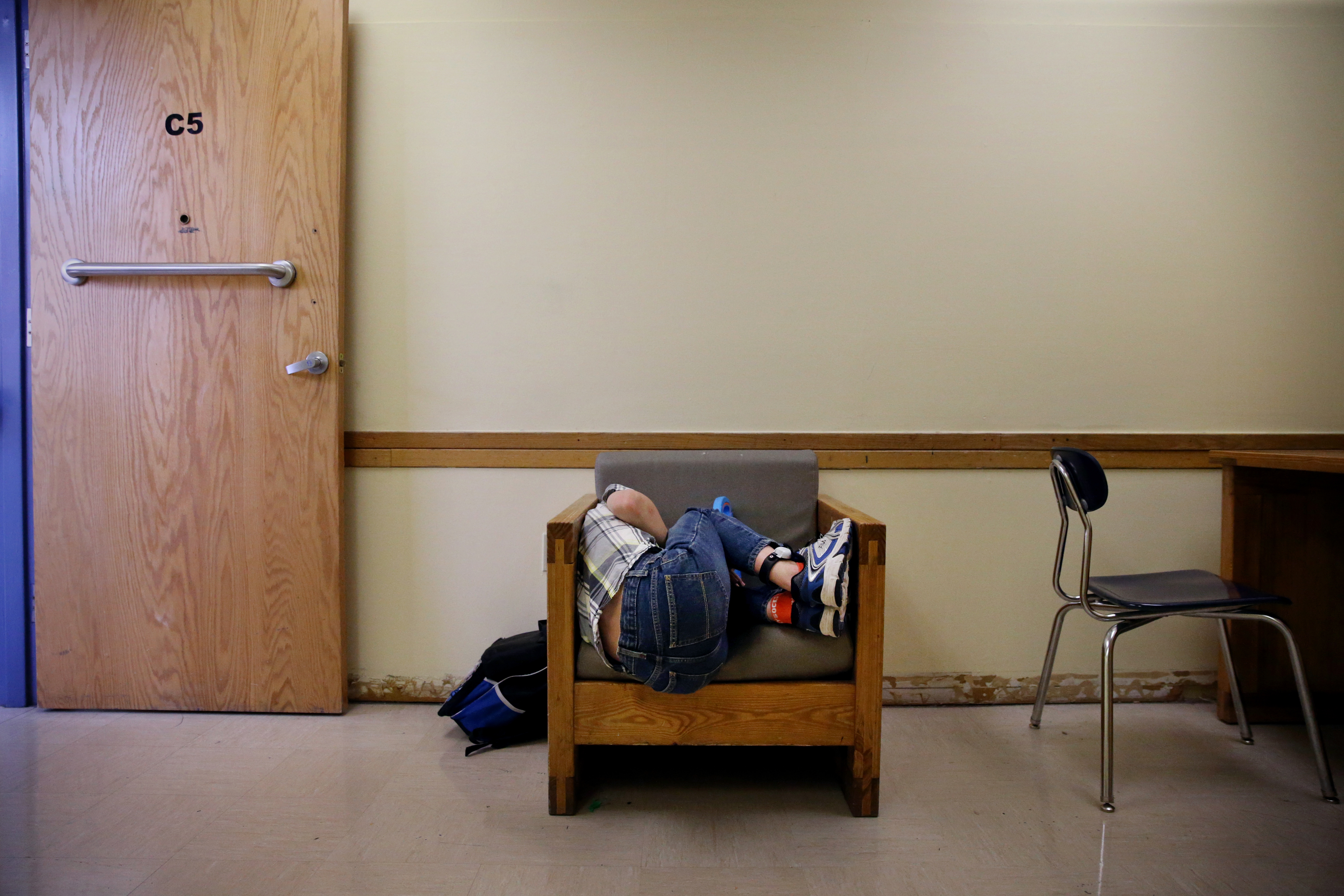Connor curled up to watch a video on his iPad in his classroom at the New England Center for Children. IPad time is a reward for good behavior. The school practices applied behavior analysis, breaking down desirable conduct into steps and rewarding children for completing each one.