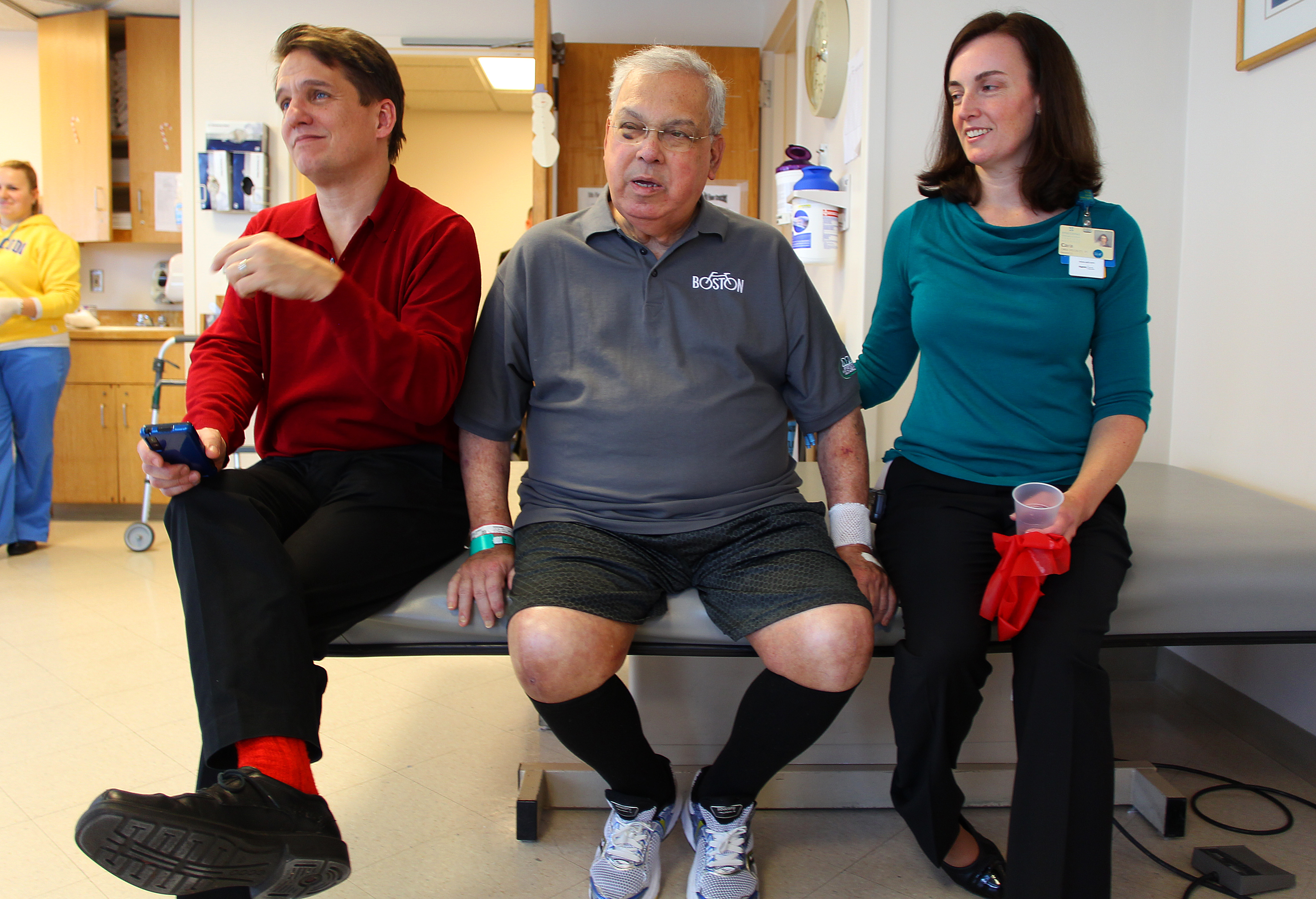 Keith Lockhart (left), the mayor, and physical therapist Cara Brickley listened to a Christmas song.